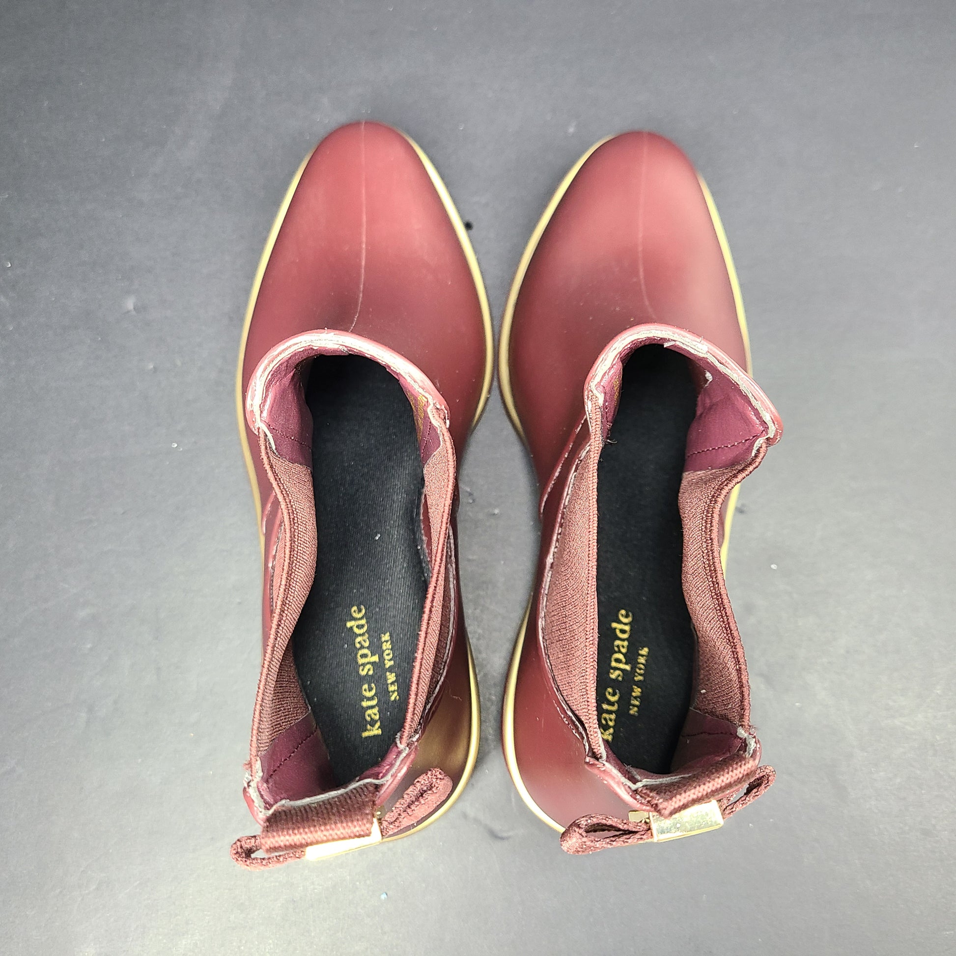 A stylish pair of Kate Spade Chelsea Ankle Boots in burgundy color