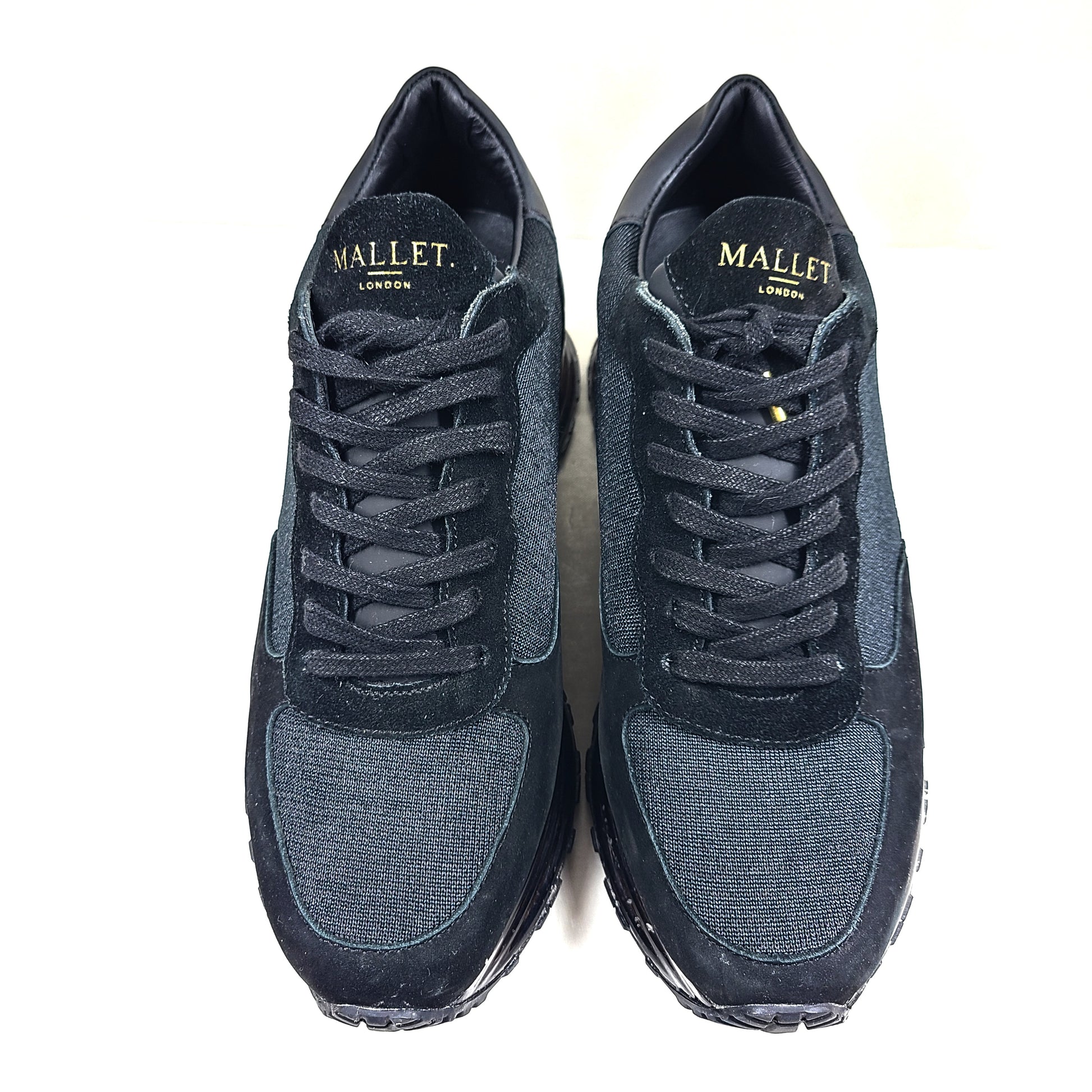 A pair of sleek black and gold Mallet London sneakers