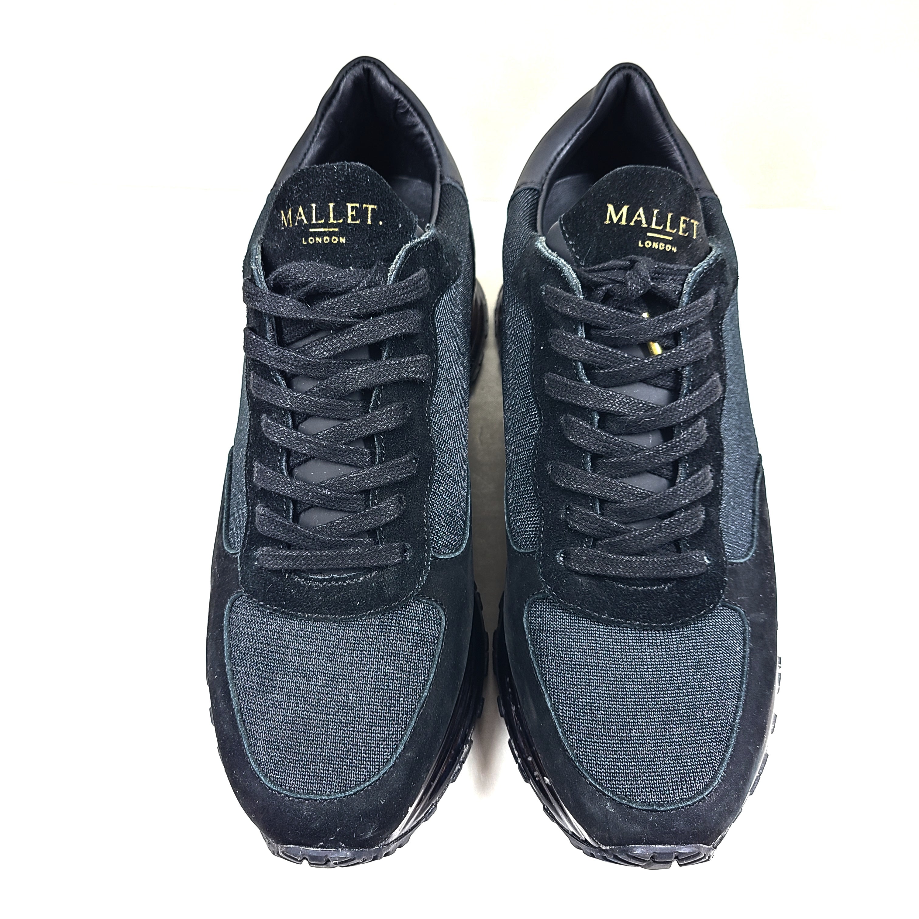 A pair of sleek black and gold Mallet London sneakers