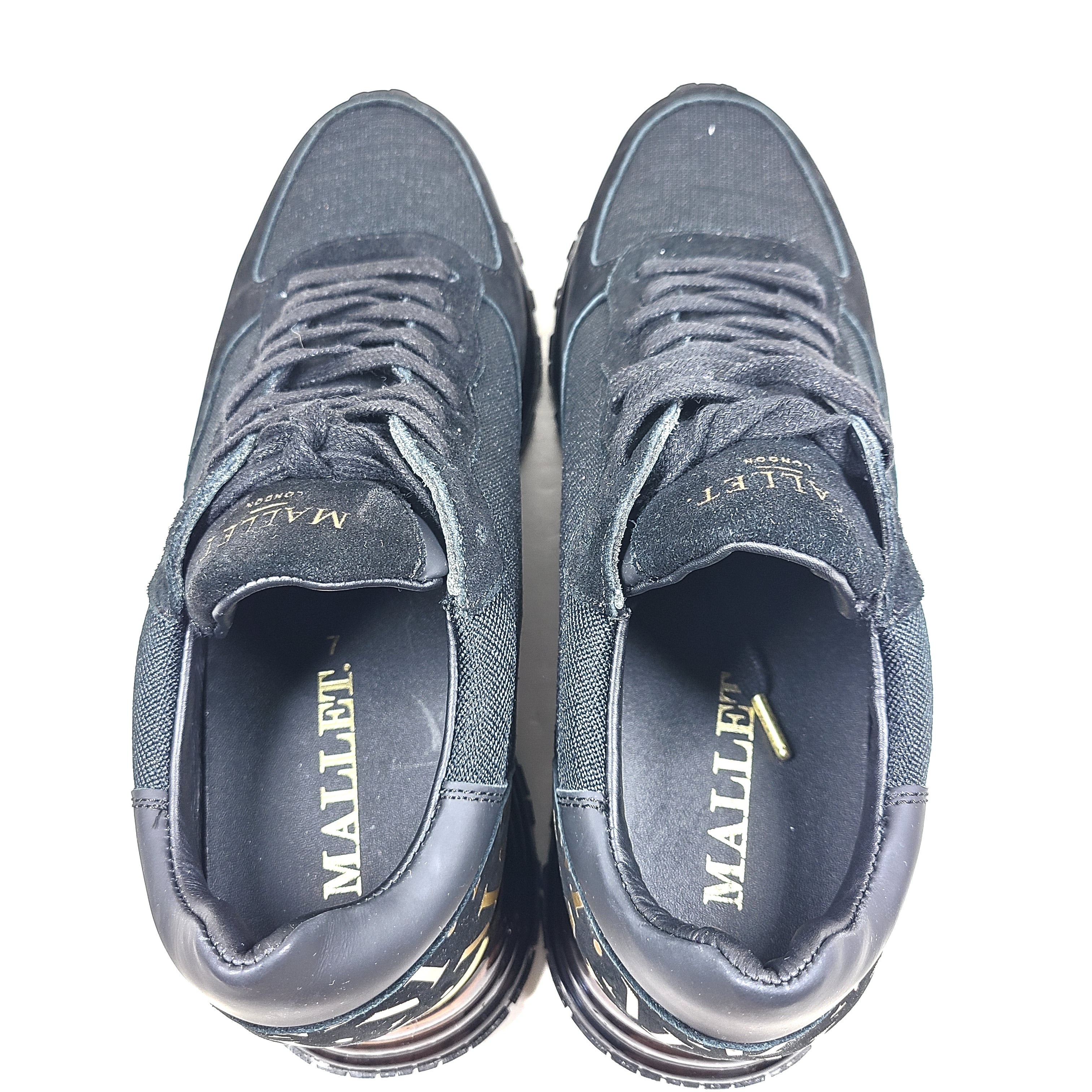 A pair of sleek black and gold Mallet London sneakers