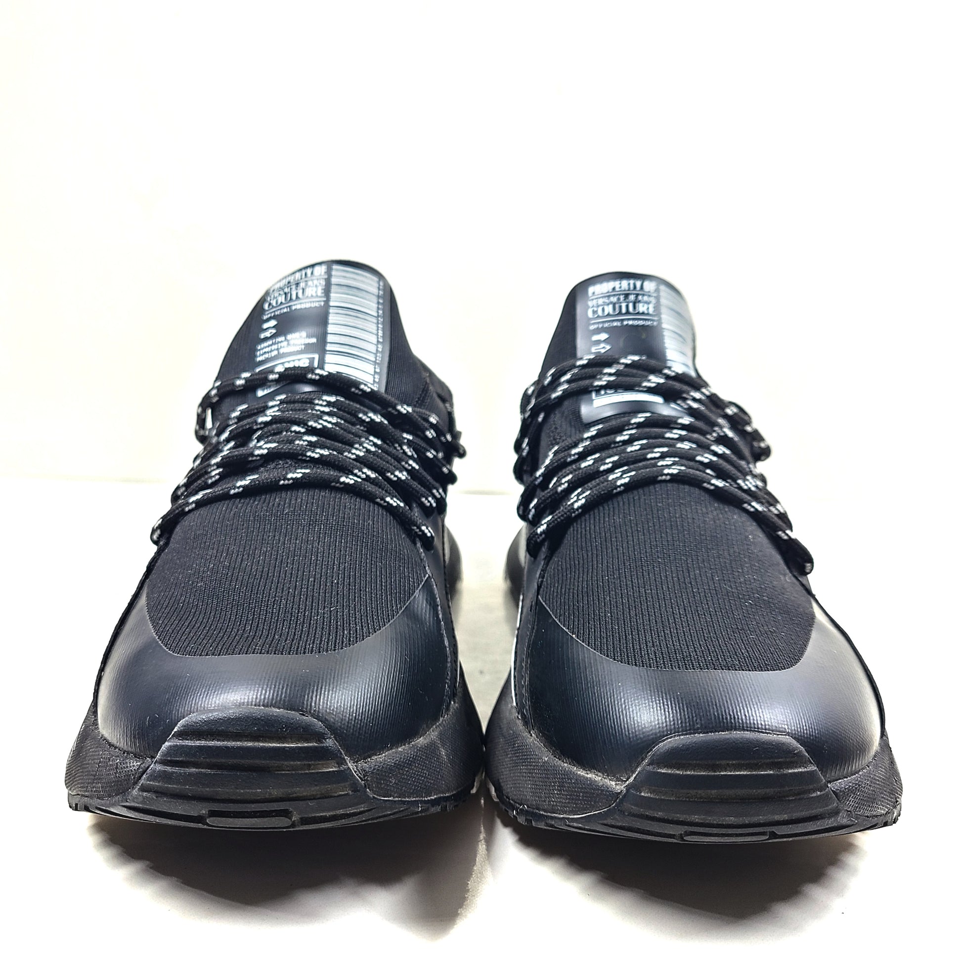 A pair of Versace Jeans Couture black sneakers with slight wear.