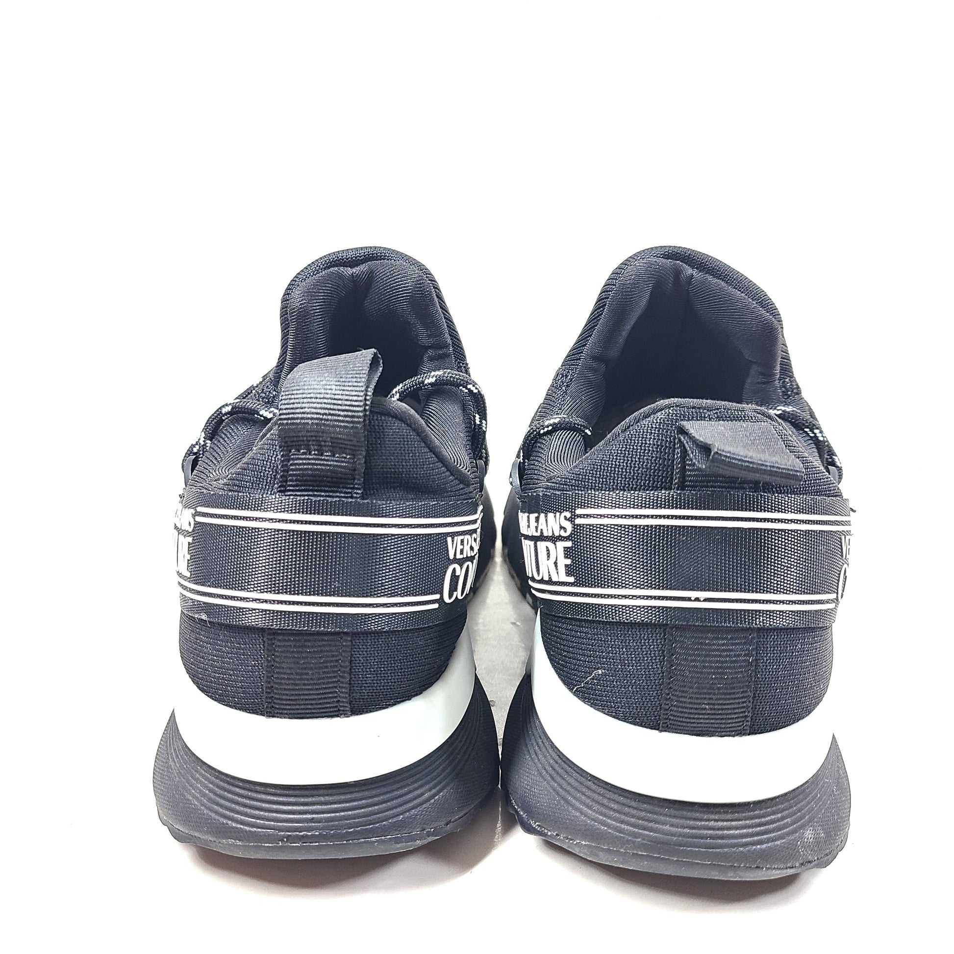 A pair of Versace Jeans Couture black sneakers with slight wear.
