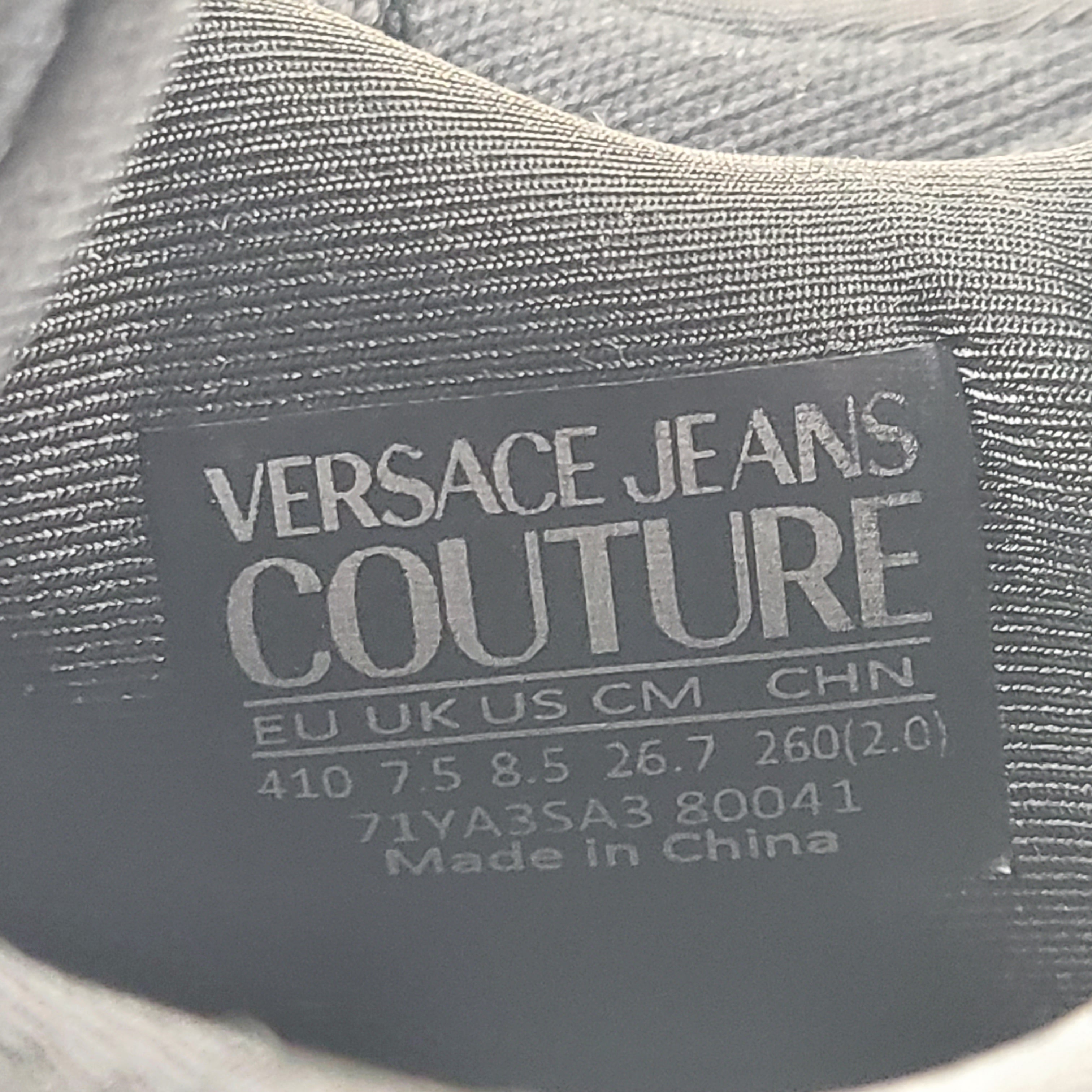 A pair of Versace Jeans Couture black sneakers with slight wear.