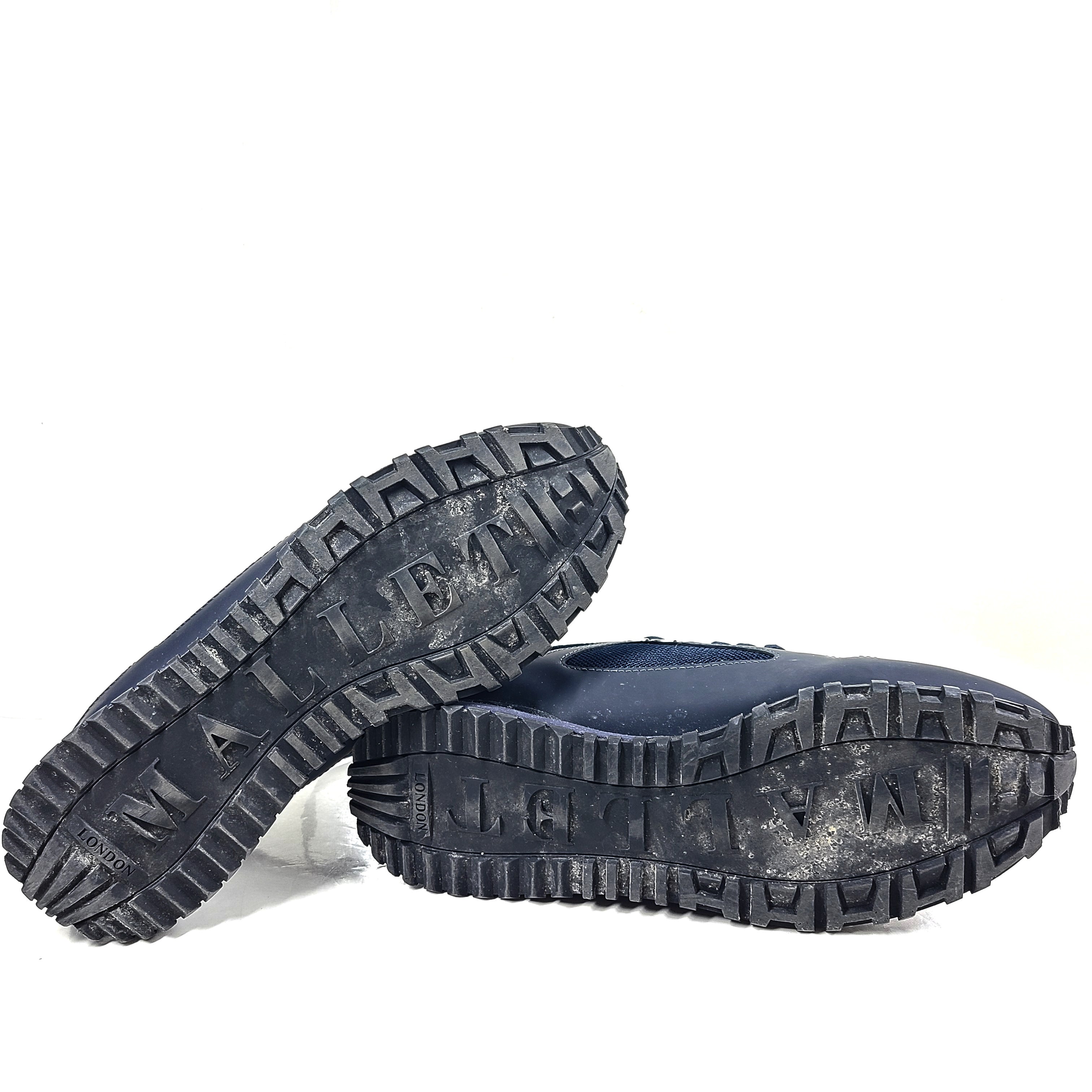 A pair of navy blue mesh and leather sneakers by Mallet.