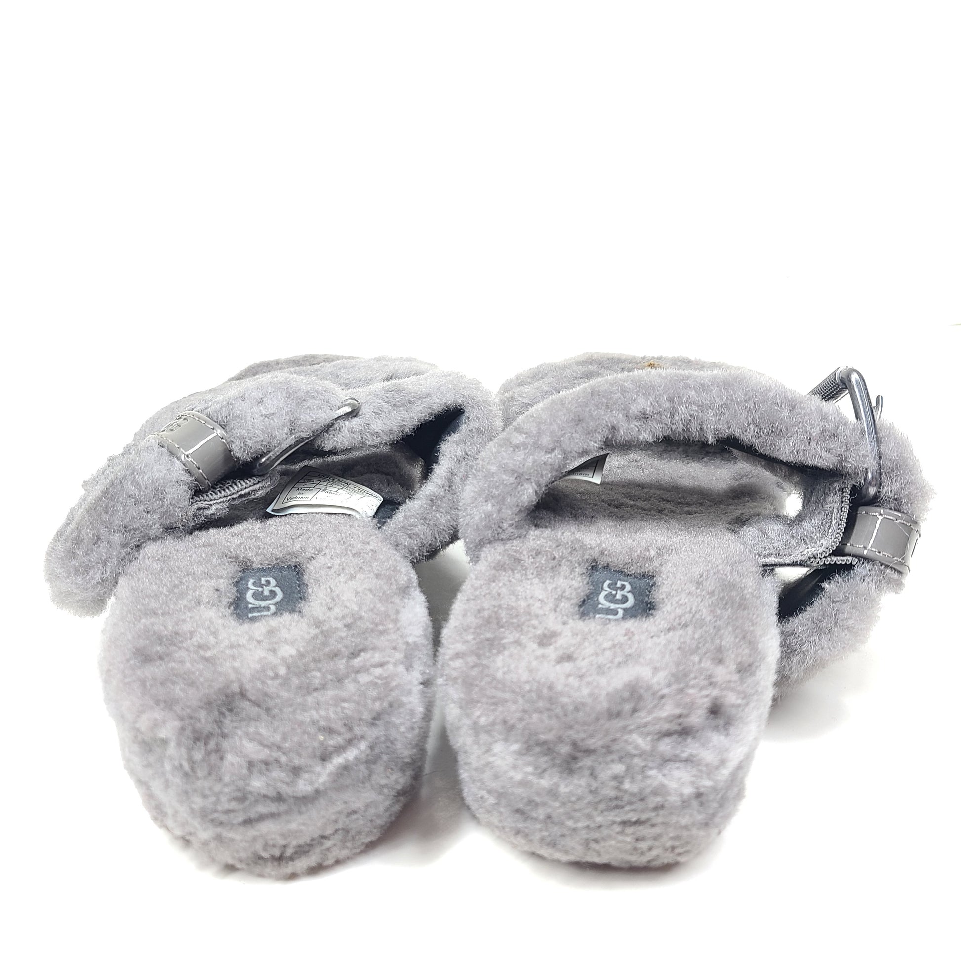 A pair of gray UGG Fluffy Sandals with adjustable straps in size 7.