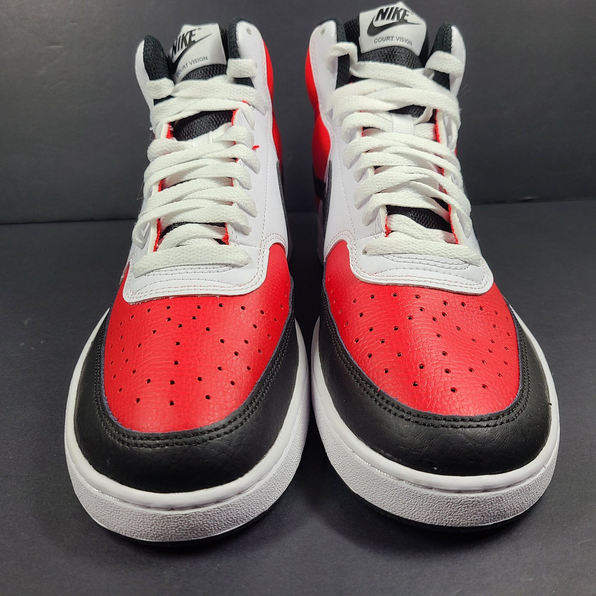 A pair of red, white, and black Nike Court Vision Mid sneakers