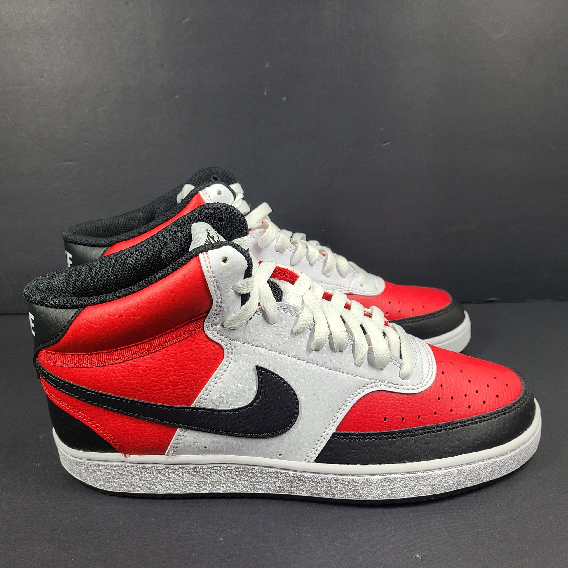 A pair of red, white, and black Nike Court Vision Mid sneakers