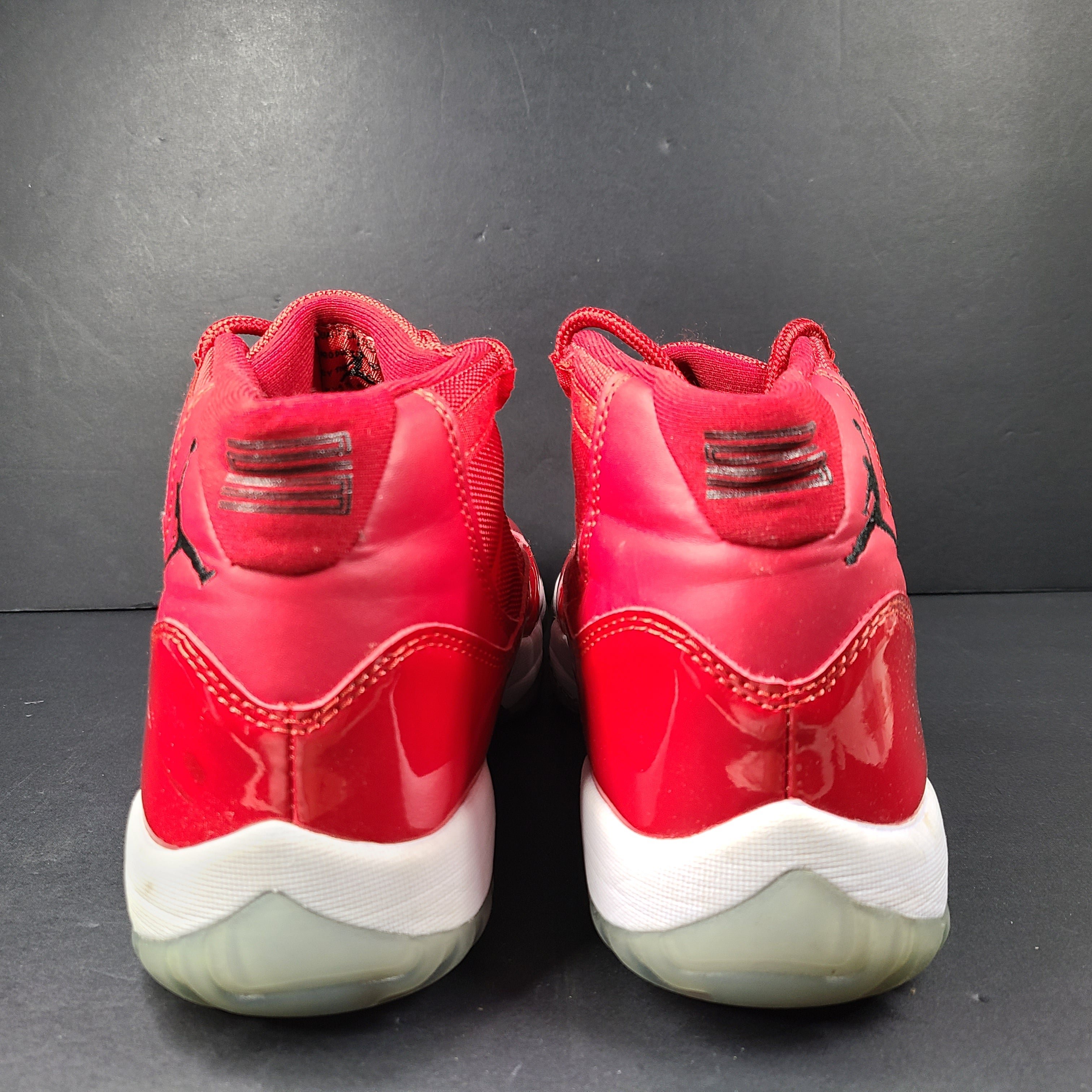 A pair of red Nike Air Jordan 11 Retro High men's sneakers.