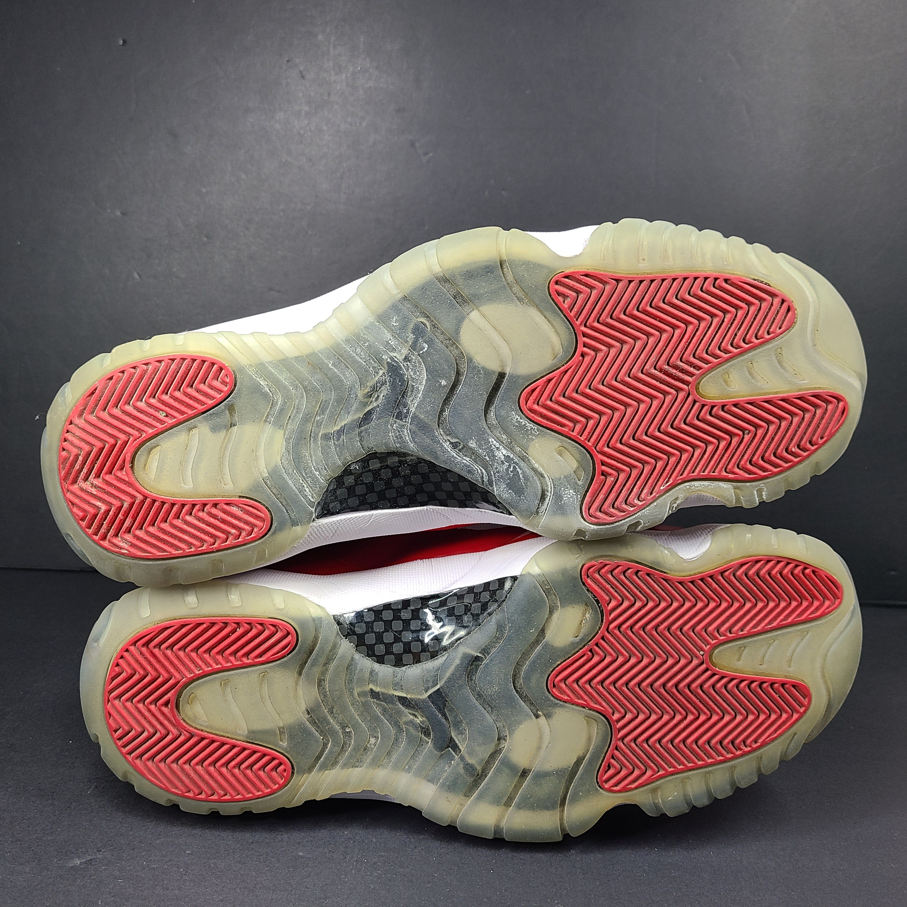 A pair of red Nike Air Jordan 11 Retro High men's sneakers.