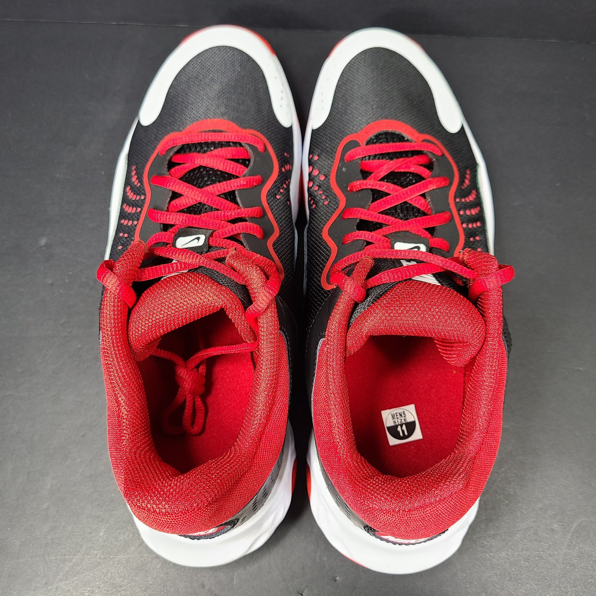 A pair of Nike men’s athletic shoes in black, red, and white.
