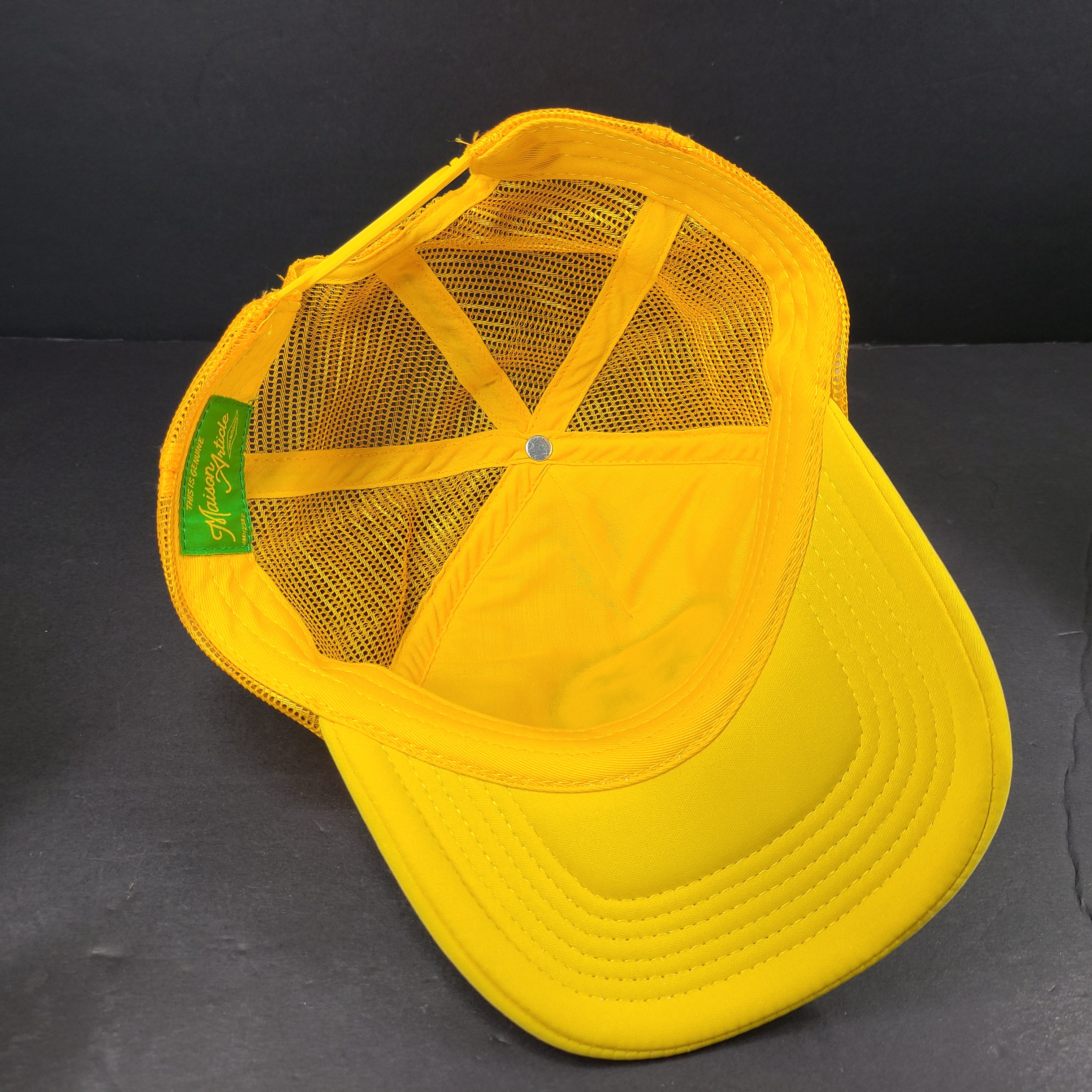 Comfortable Maison Article Trucker Cap in yellow and white mesh design.