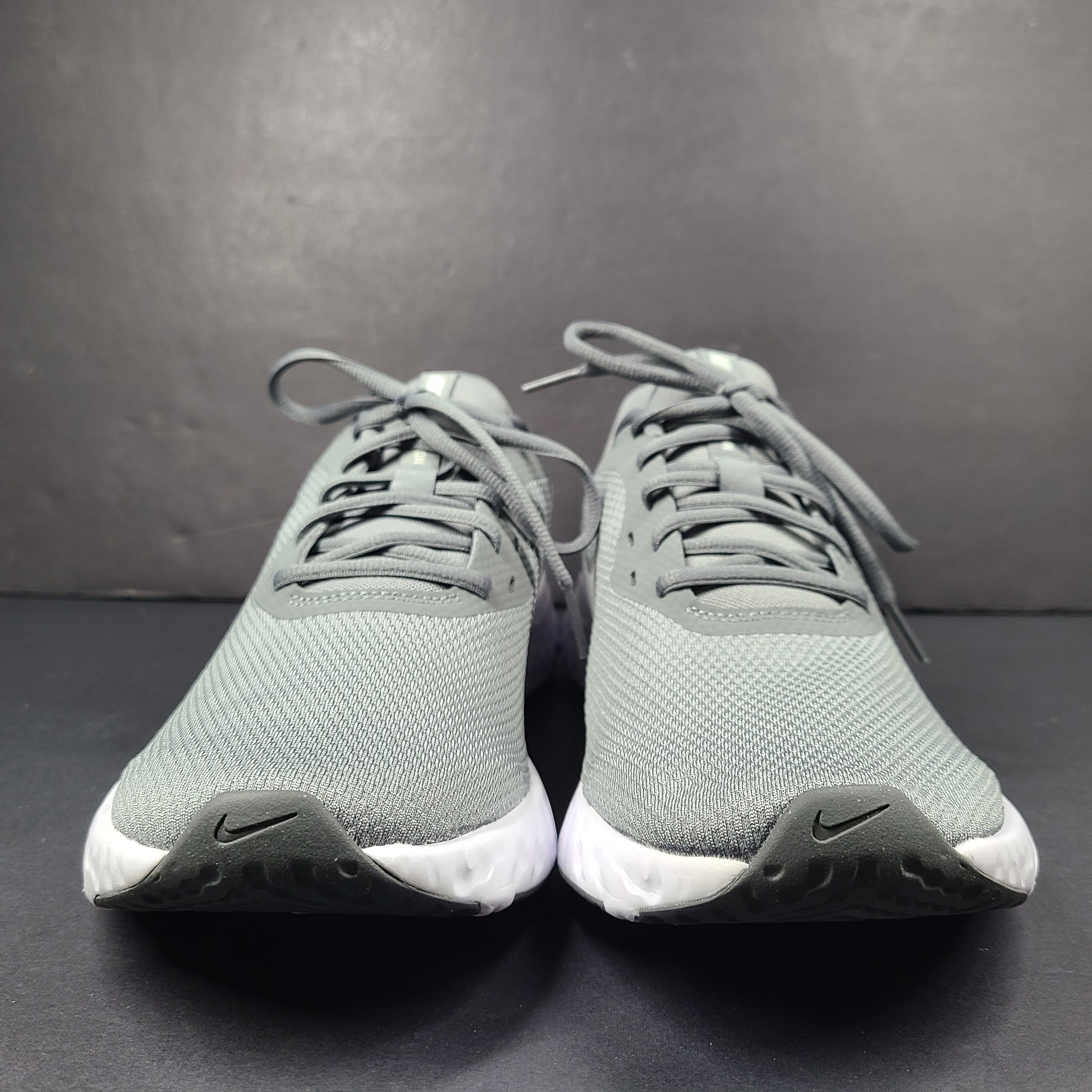 A pair of Nike Revolution 5 Men's Running Shoes in grey and white.