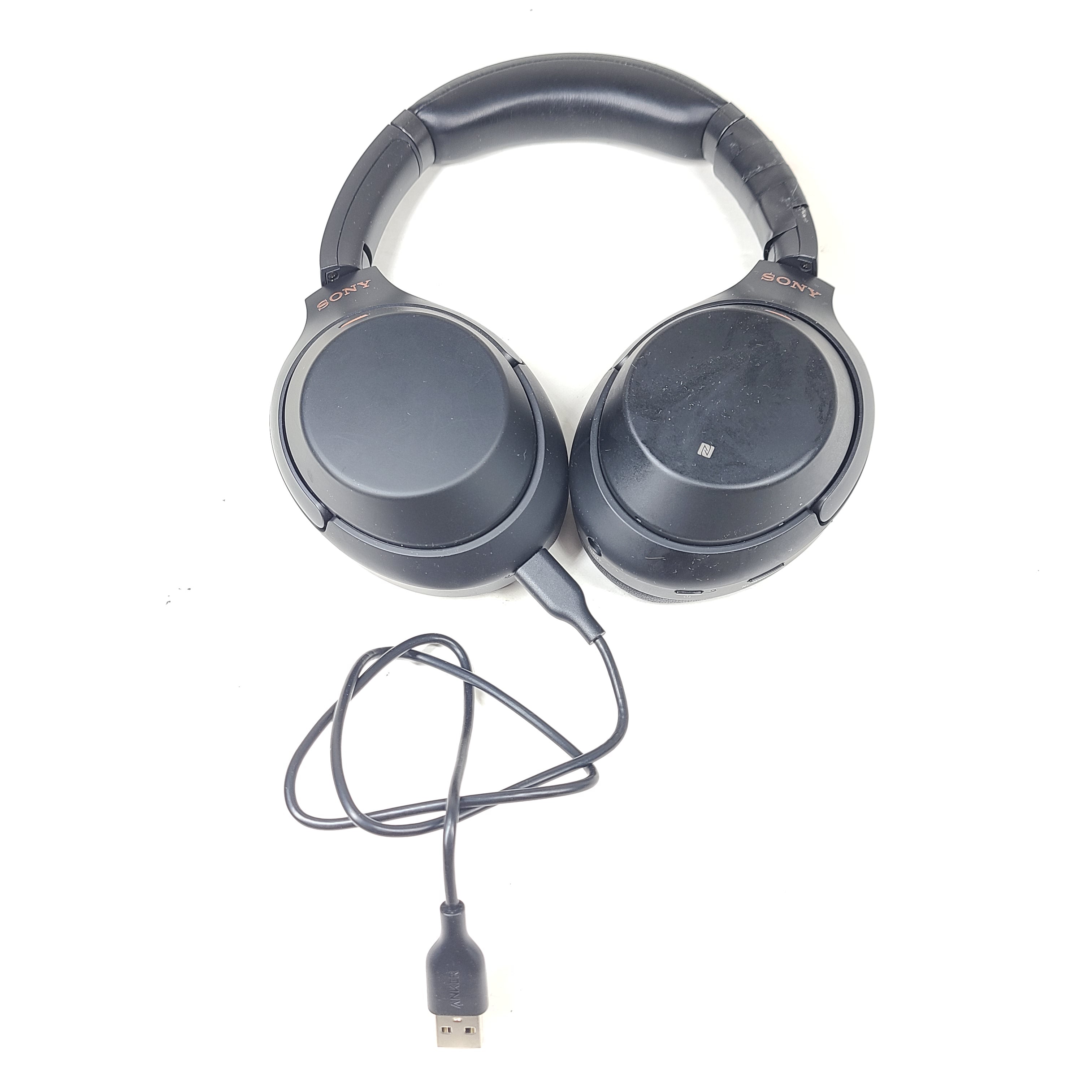 Black Sony WH-1000XM3 over-ear wireless noise-cancelling headphones with NFC on the ear cups and USB charging cable included.