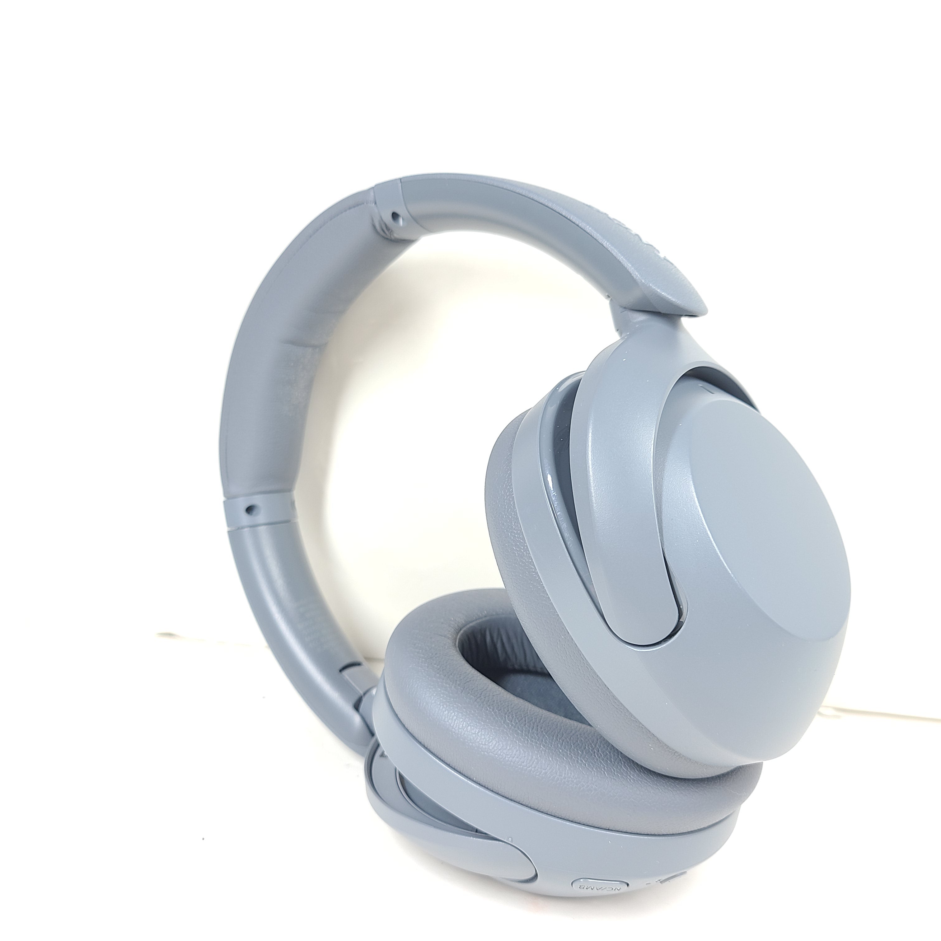 Premium wireless over-ear headphones with active noise cancellation and a cushioned headband in gray.