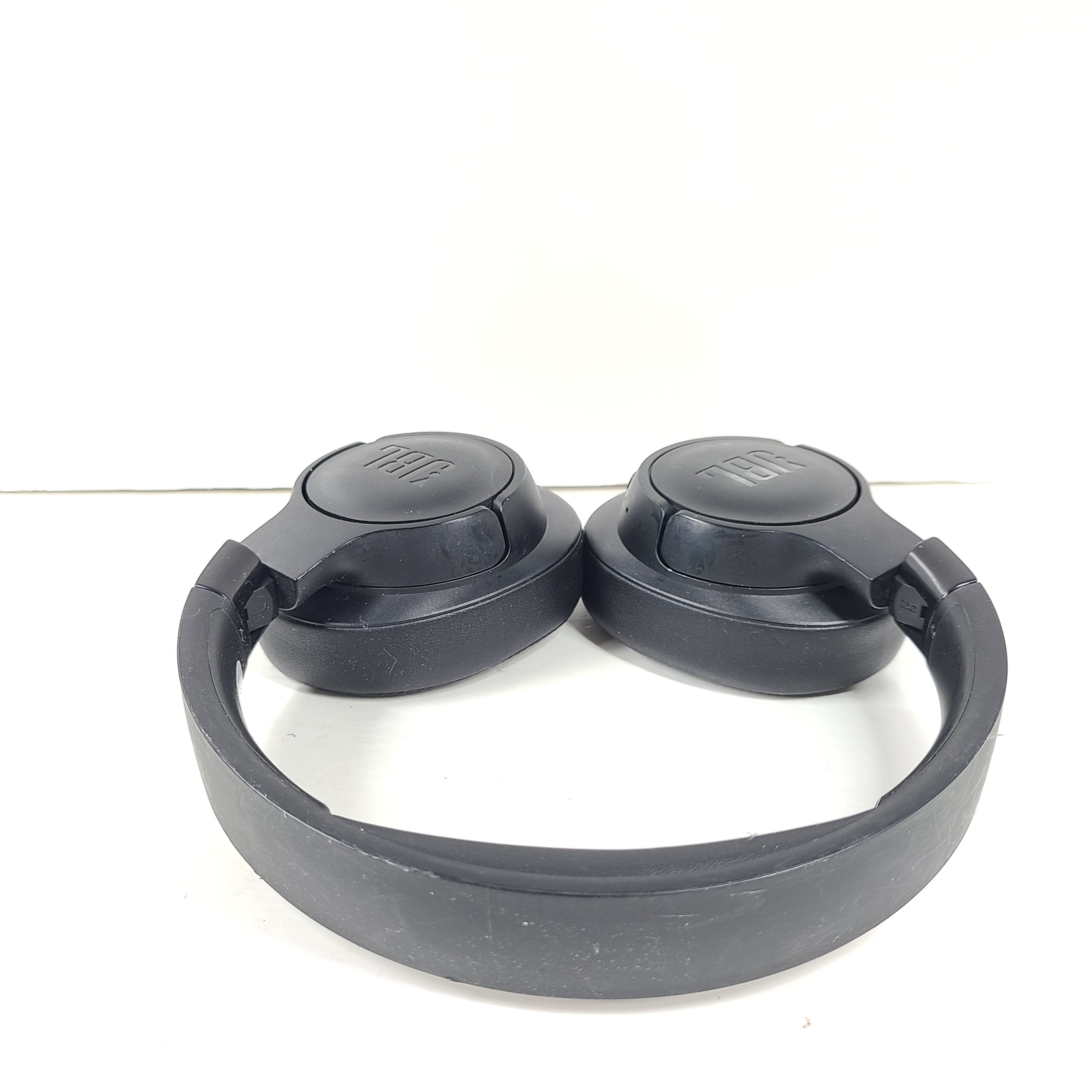 Over-ear JBL Tune 710BT wireless headphones in black with cushioned ear pads and adjustable headband for comfortable listening.