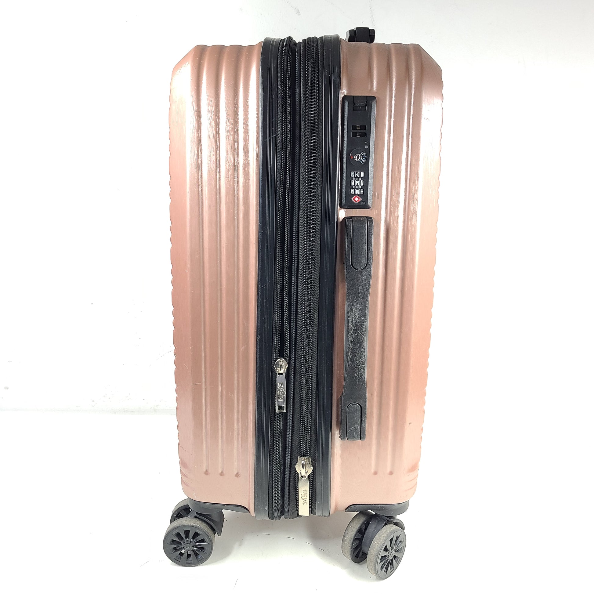 Rose gold Heys Aerolite hardshell carry-on with spinner wheels and telescoping handle for smooth travel.