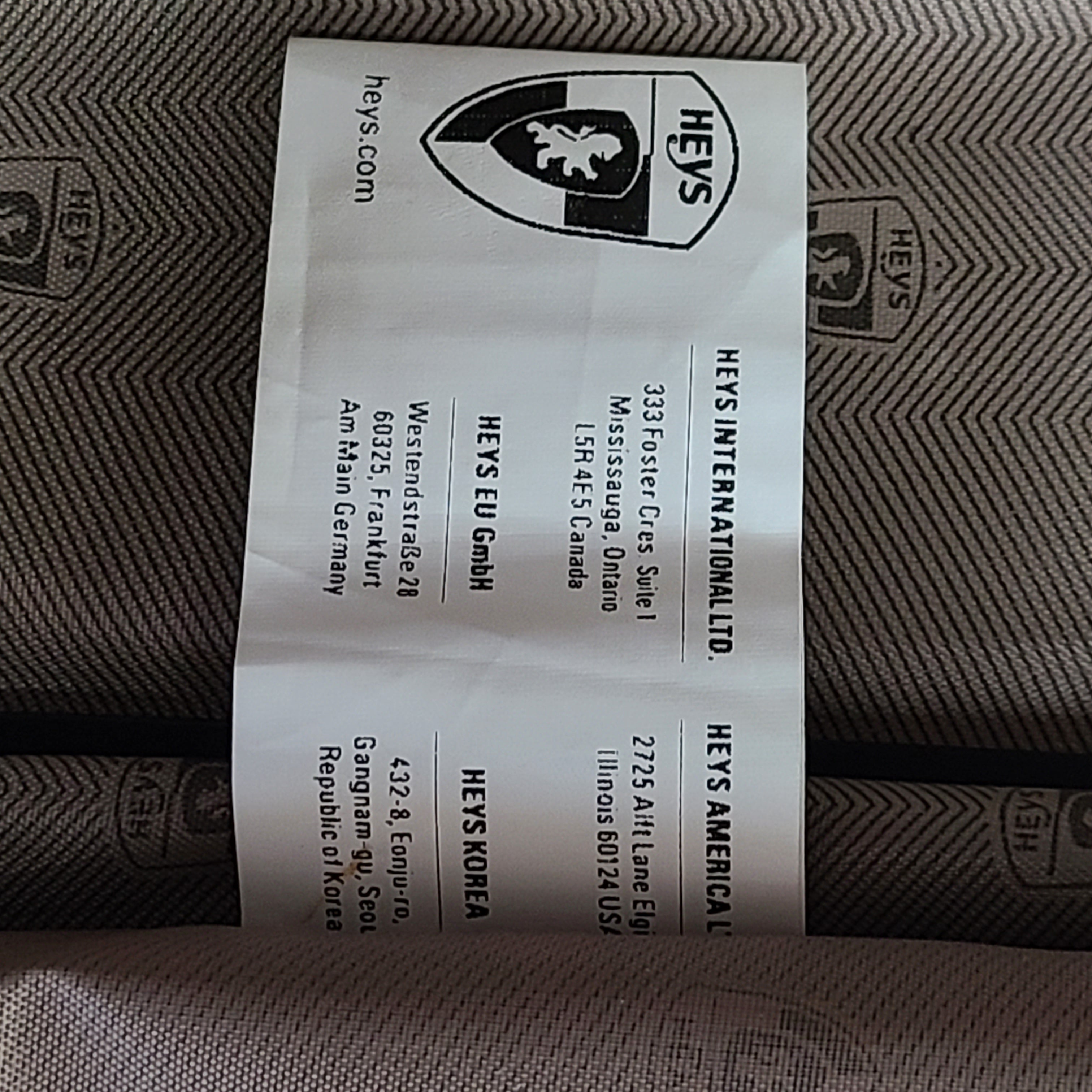 Rose gold Heys Aerolite hardshell carry-on with spinner wheels and telescoping handle for smooth travel.