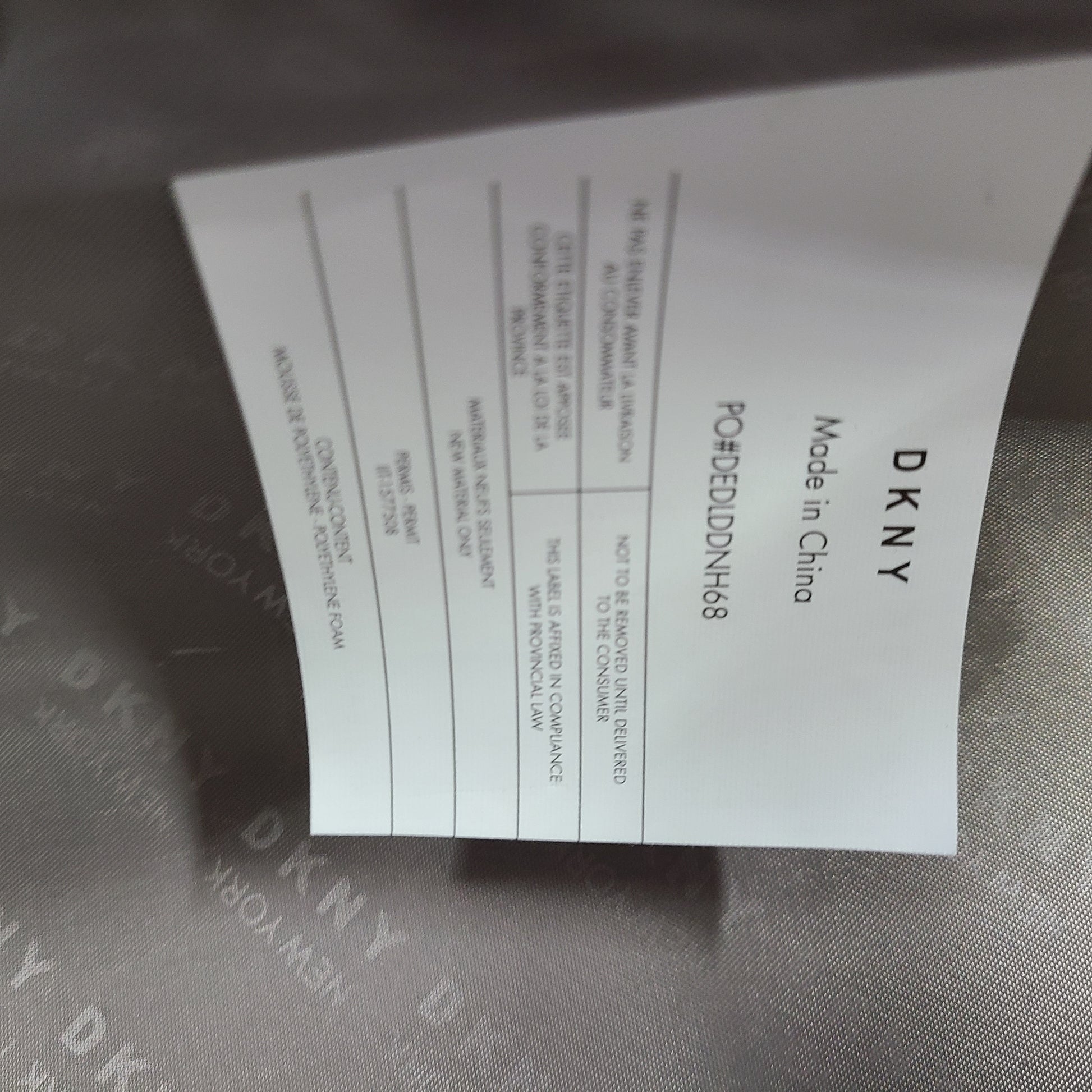 Gold DKNY suitcase with minor surface scratches and a clean interior, branded DKNY NEW YORK EST.1989.