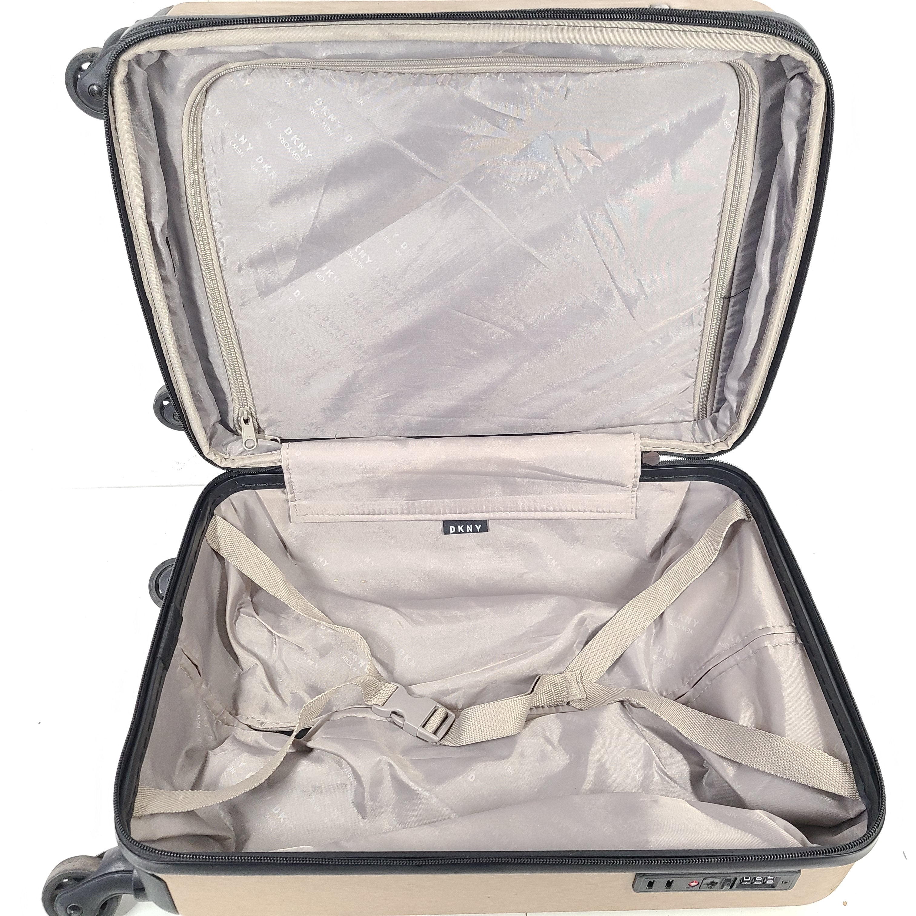 Gold DKNY suitcase with minor surface scratches and a clean interior, branded DKNY NEW YORK EST.1989.