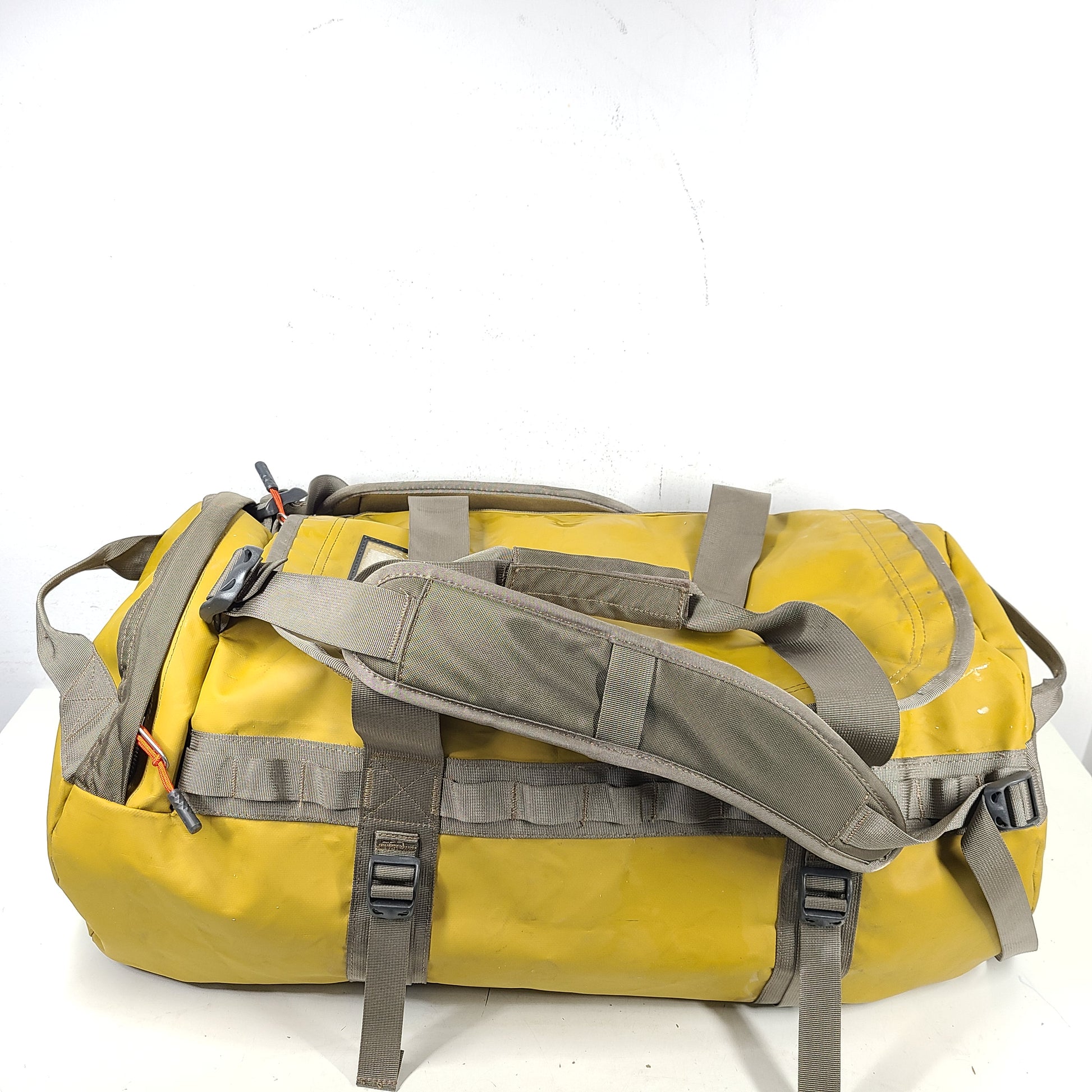 The North Face medium Base Camp duffel in yellow and grey with reinforced handles and adjustable shoulder straps.