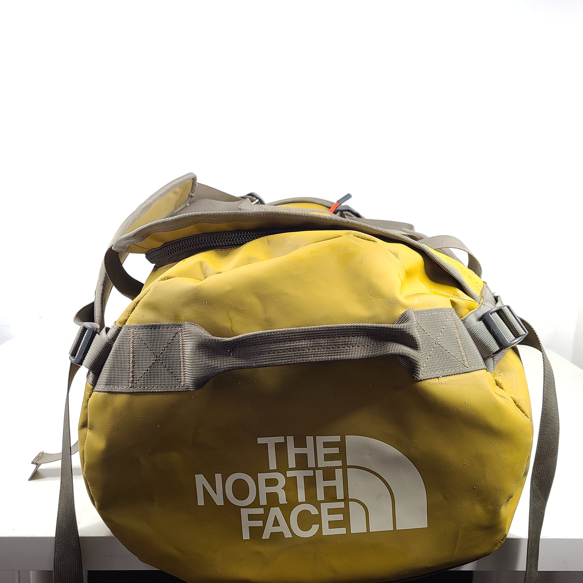 The North Face medium Base Camp duffel in yellow and grey with reinforced handles and adjustable shoulder straps.