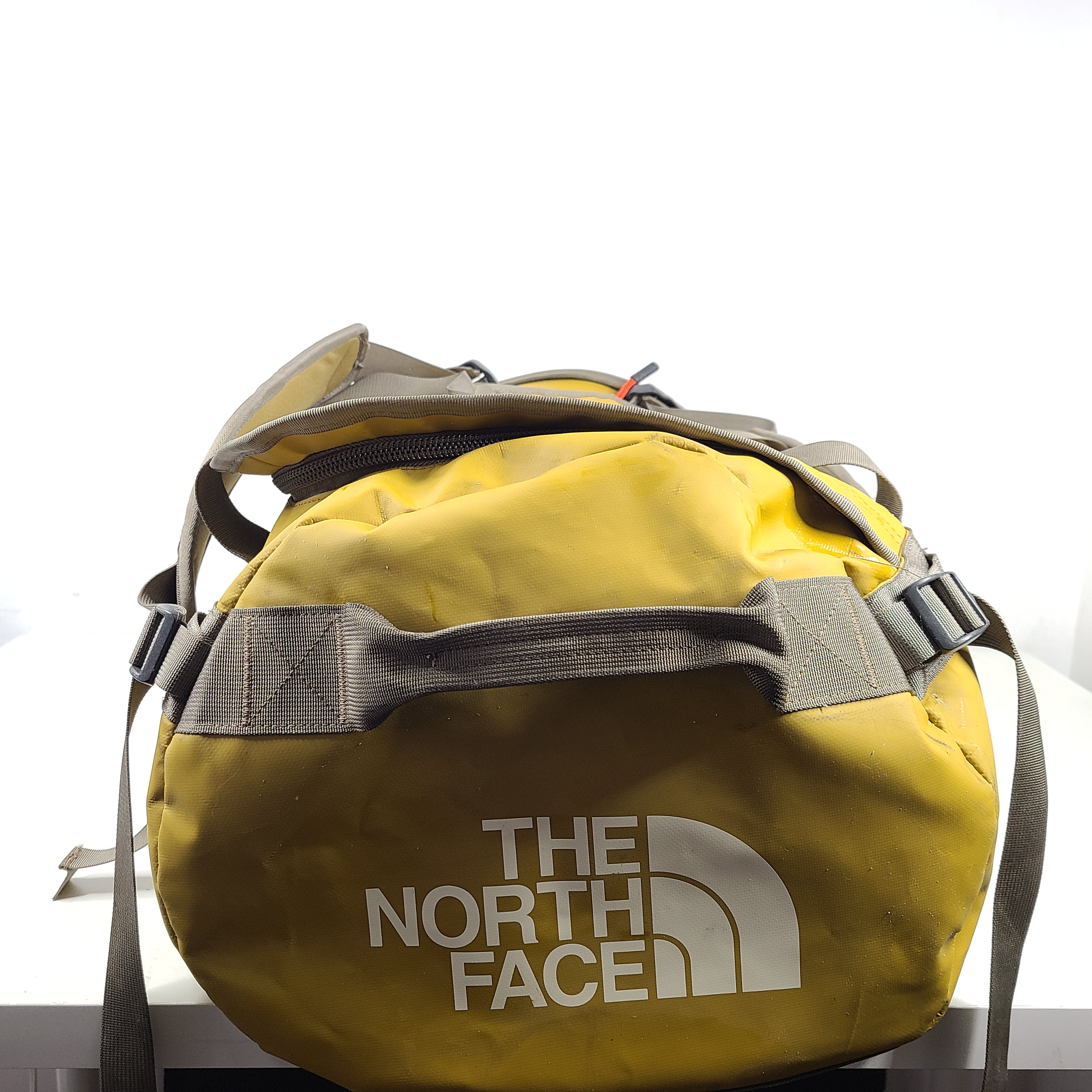 The North Face medium Base Camp duffel in yellow and grey with reinforced handles and adjustable shoulder straps.