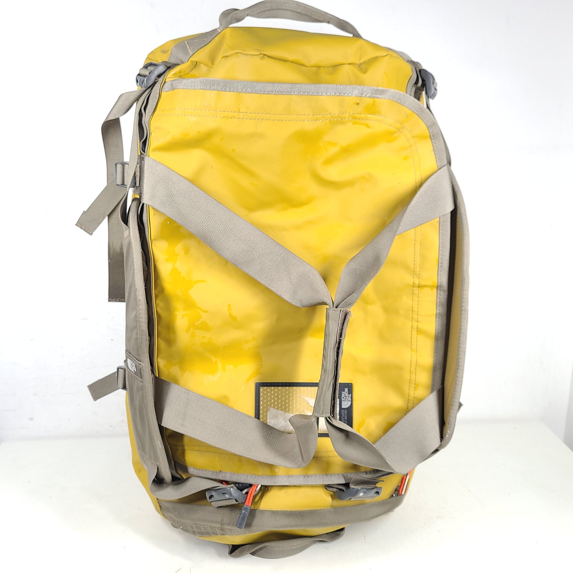 The North Face medium Base Camp duffel in yellow and grey with reinforced handles and adjustable shoulder straps.