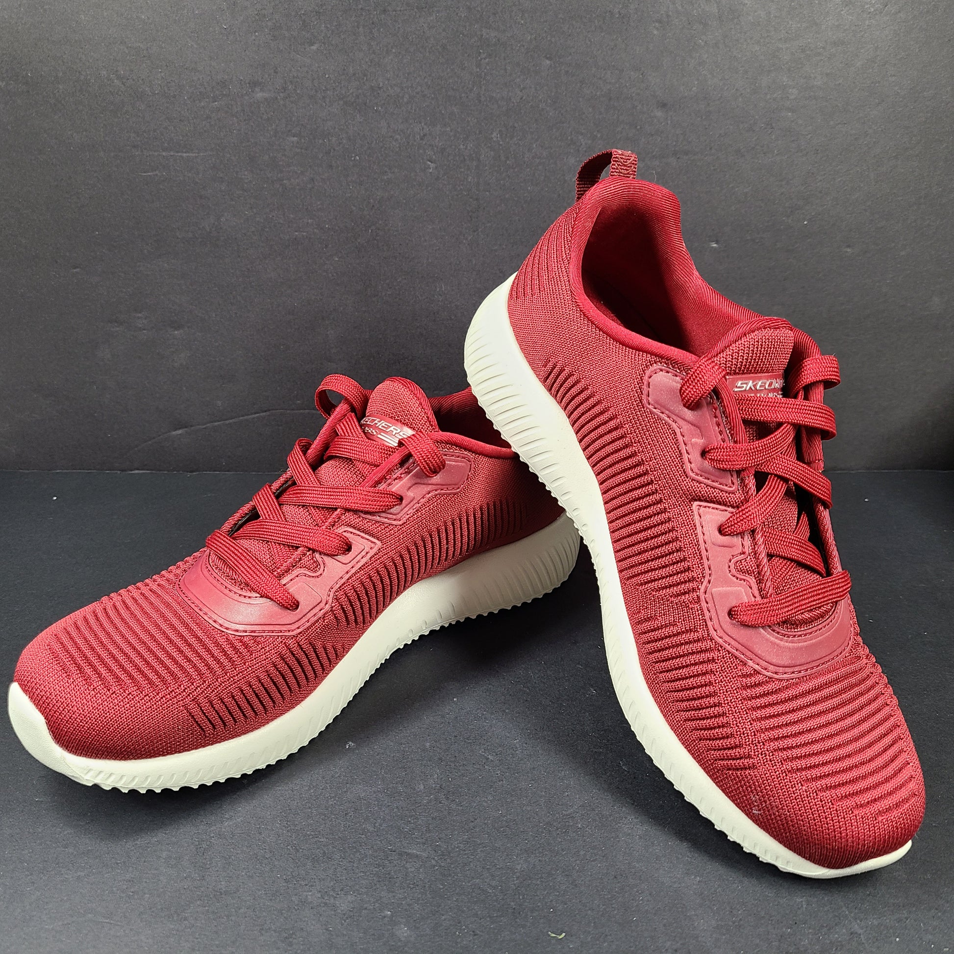 Red Skechers BOBS women's sneaker with cushioned memory foam insole and knit upper for everyday comfort.