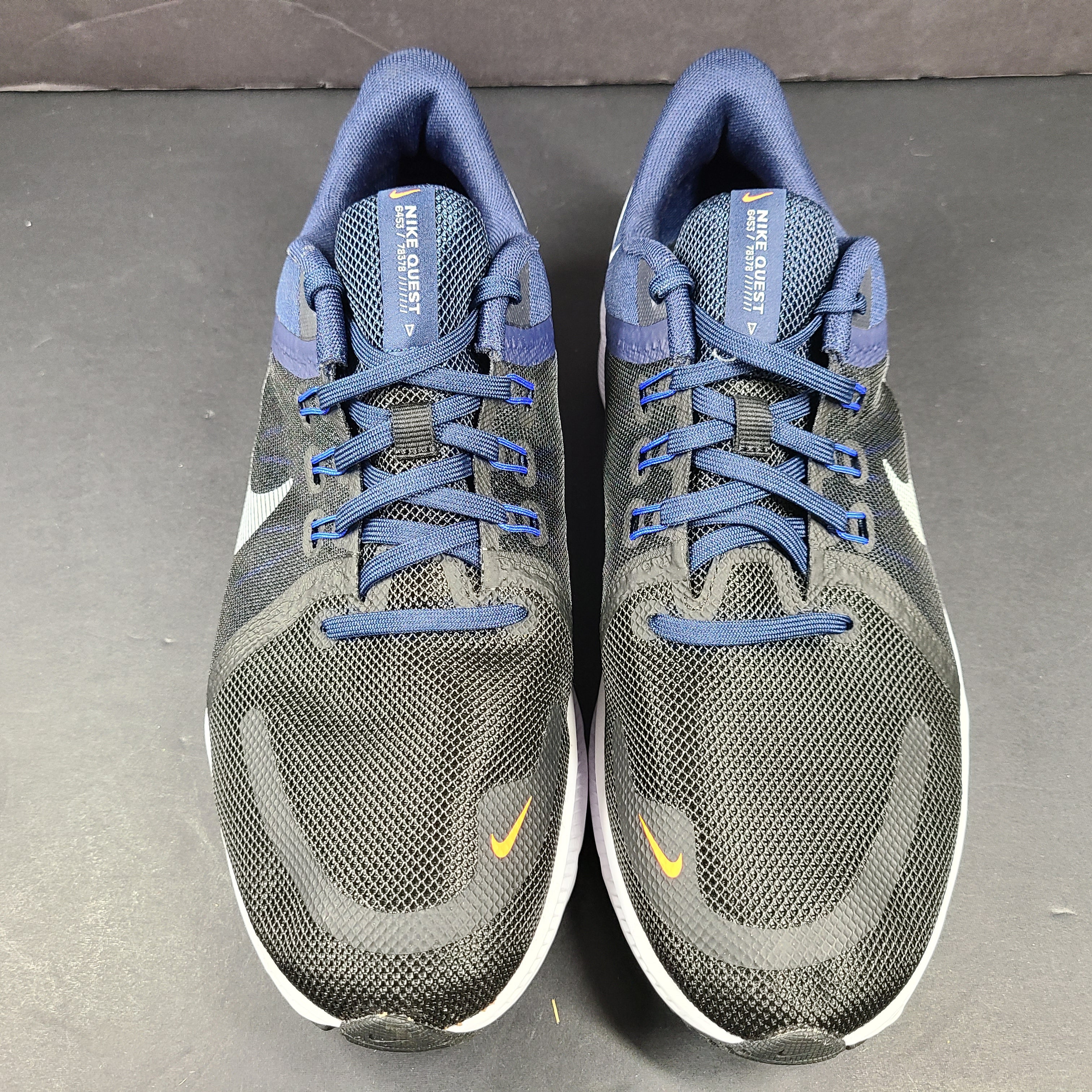 Black, blue and orange Nike Quest 4 running shoes in US size 9 with breathable mesh upper and cushioned sole.