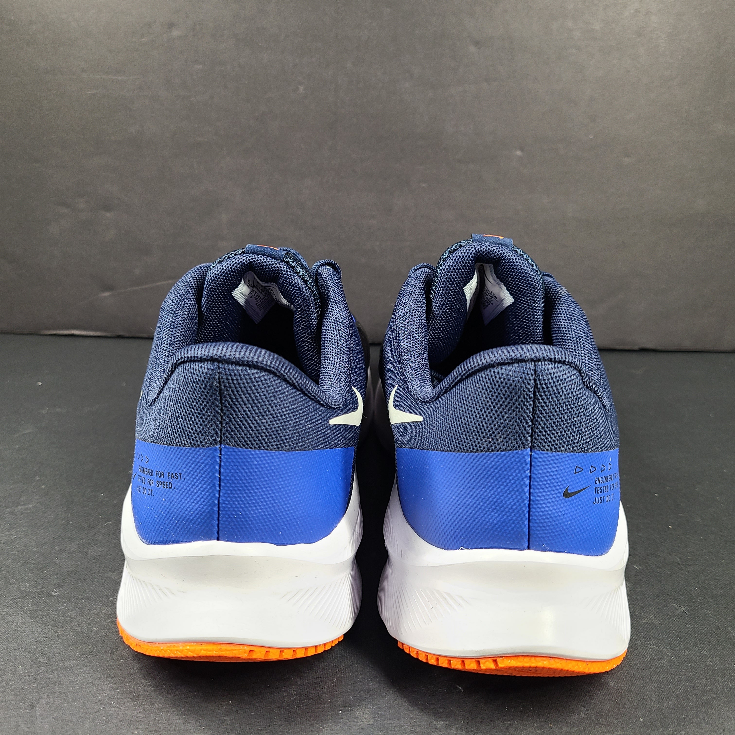 Black, blue and orange Nike Quest 4 running shoes in US size 9 with breathable mesh upper and cushioned sole.