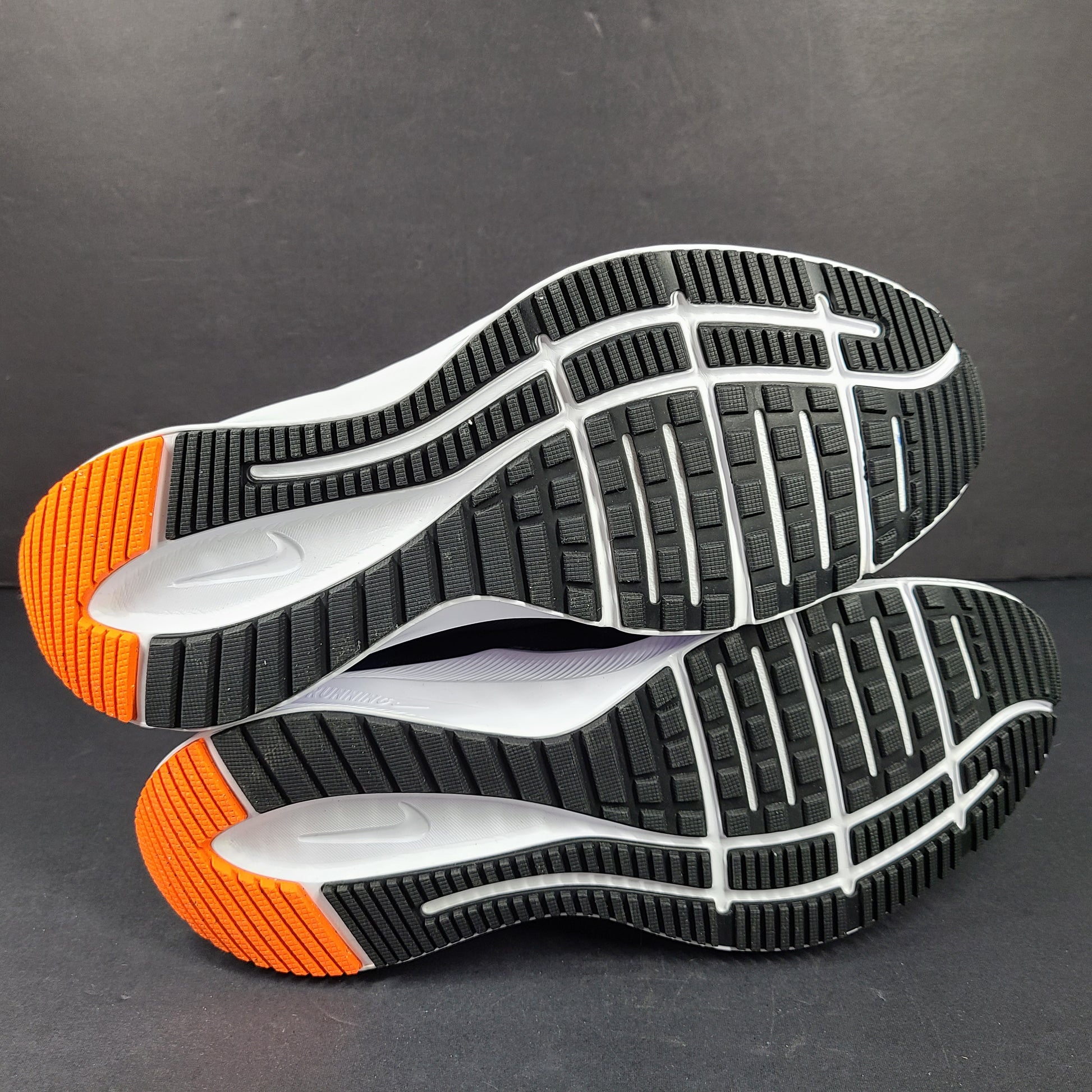Black, blue and orange Nike Quest 4 running shoes in US size 9 with breathable mesh upper and cushioned sole.