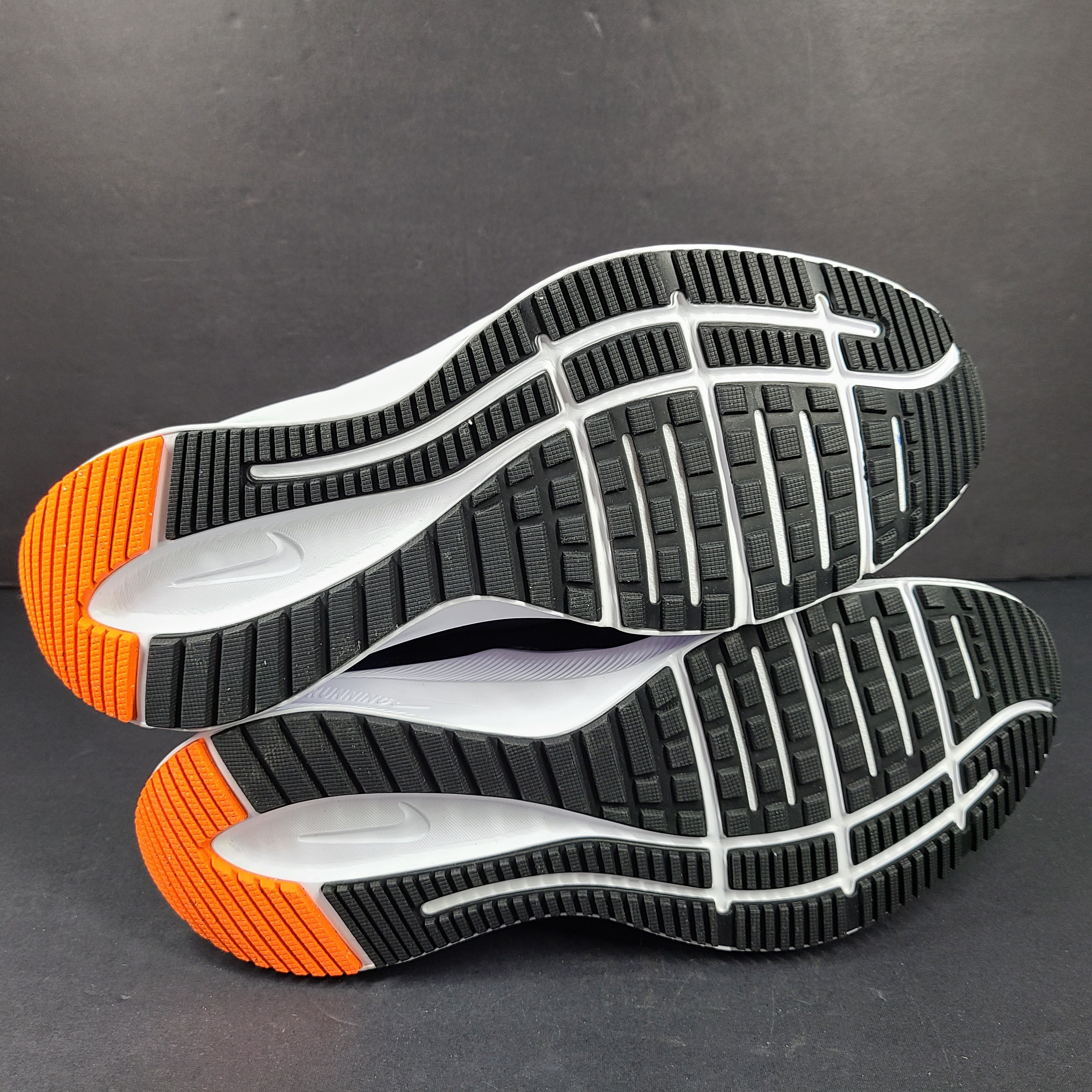 Black, blue and orange Nike Quest 4 running shoes in US size 9 with breathable mesh upper and cushioned sole.