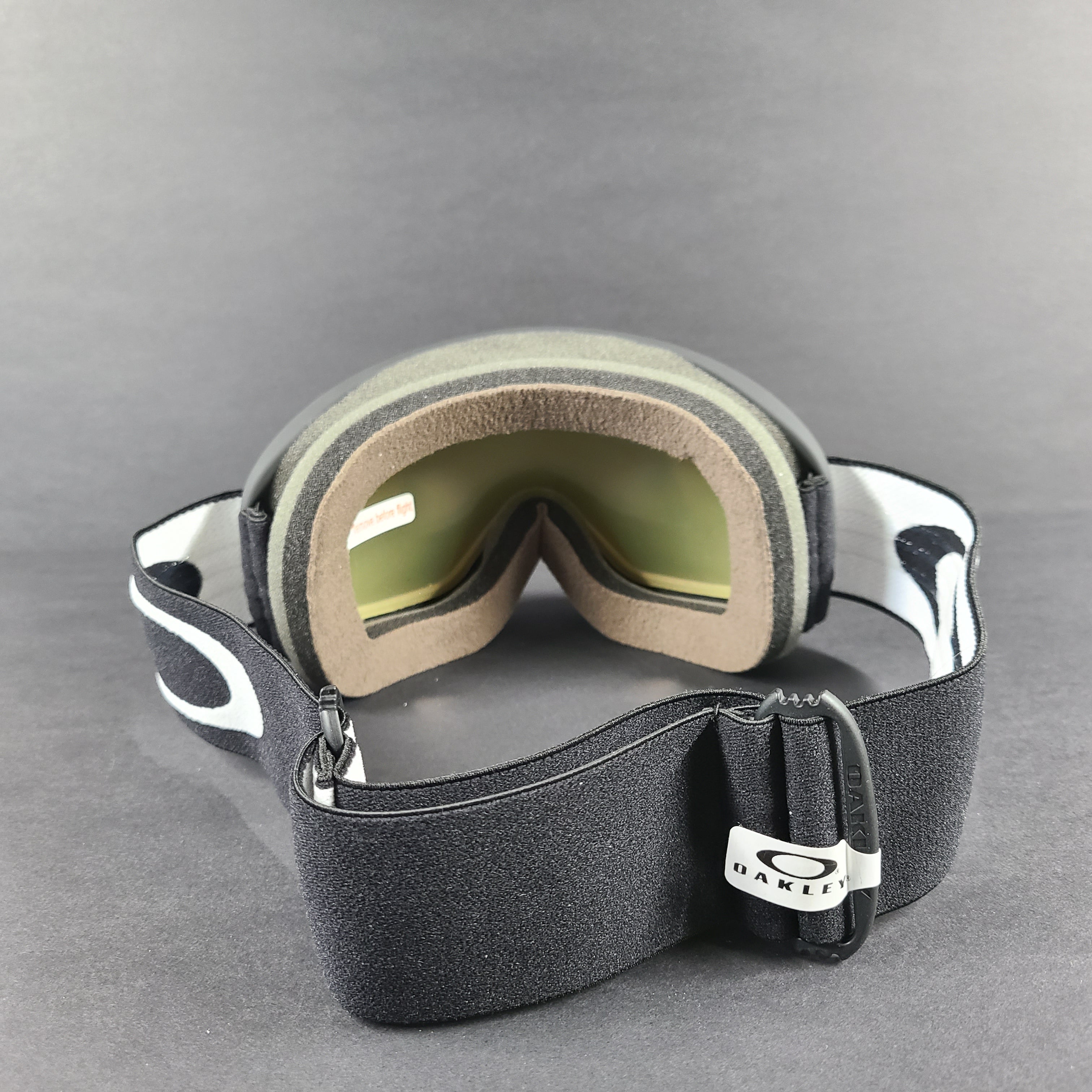 Oakley black snow goggles feature an orange lens and include an extra replacement lens and storage bag.