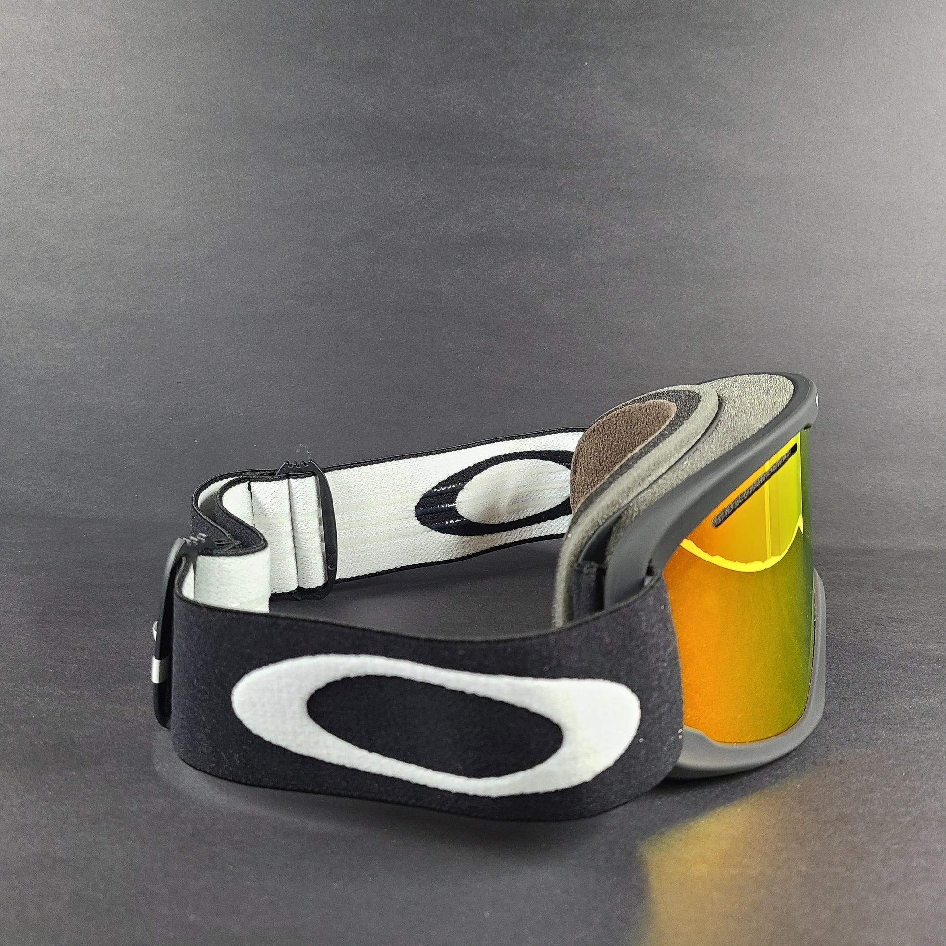 Oakley black snow goggles feature an orange lens and include an extra replacement lens and storage bag.