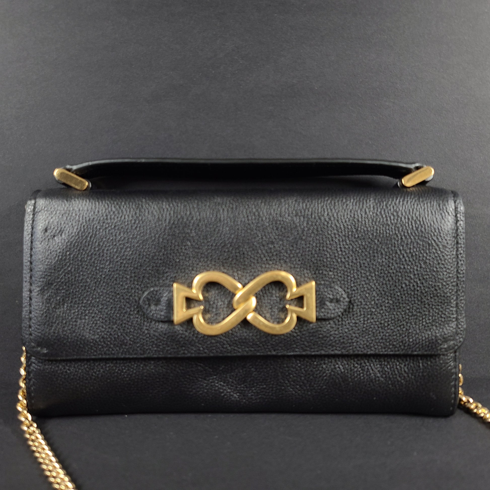 Black Kate Spade leather crossbody handbag with gold chain strap and branded logo.