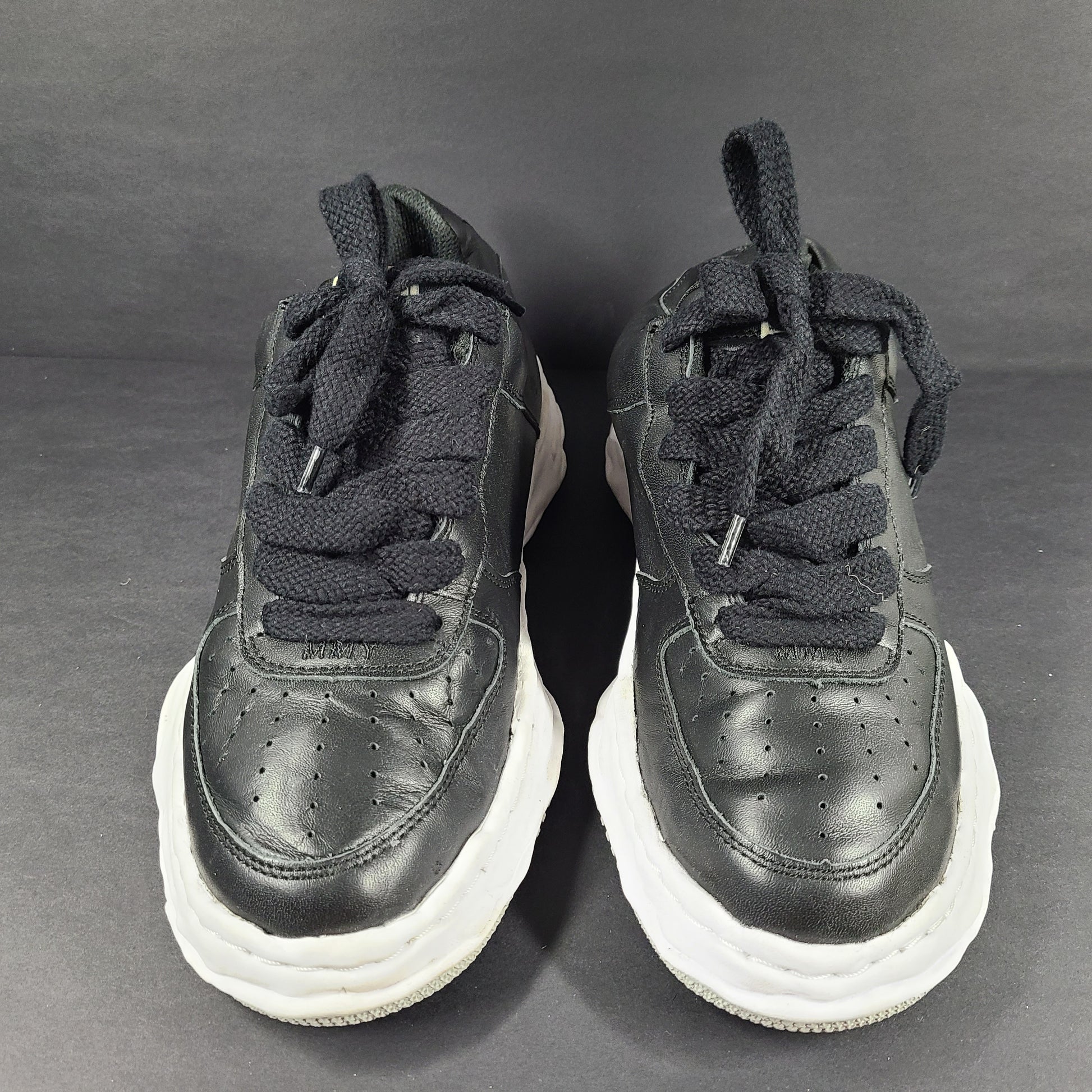 Black and white Maison Mihara Yasuhiro Wayne low-top leather sneakers with original sculpted OG sole and MMY branding.