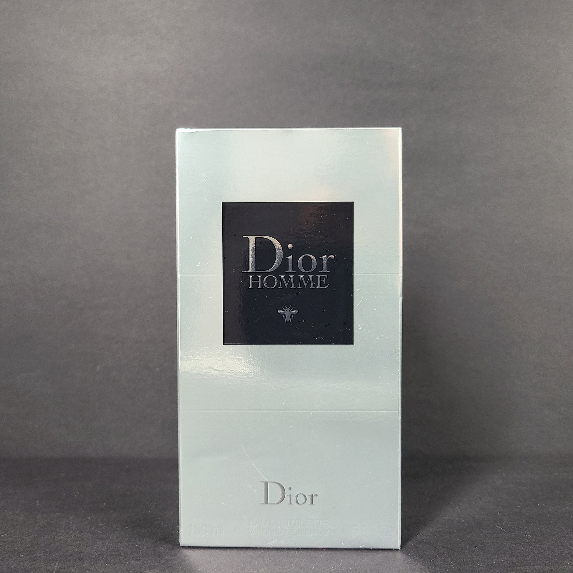Clear glass perfume bottle labeled Dior Homme Eau de Toilette 150ml with clean, minimalist branding.