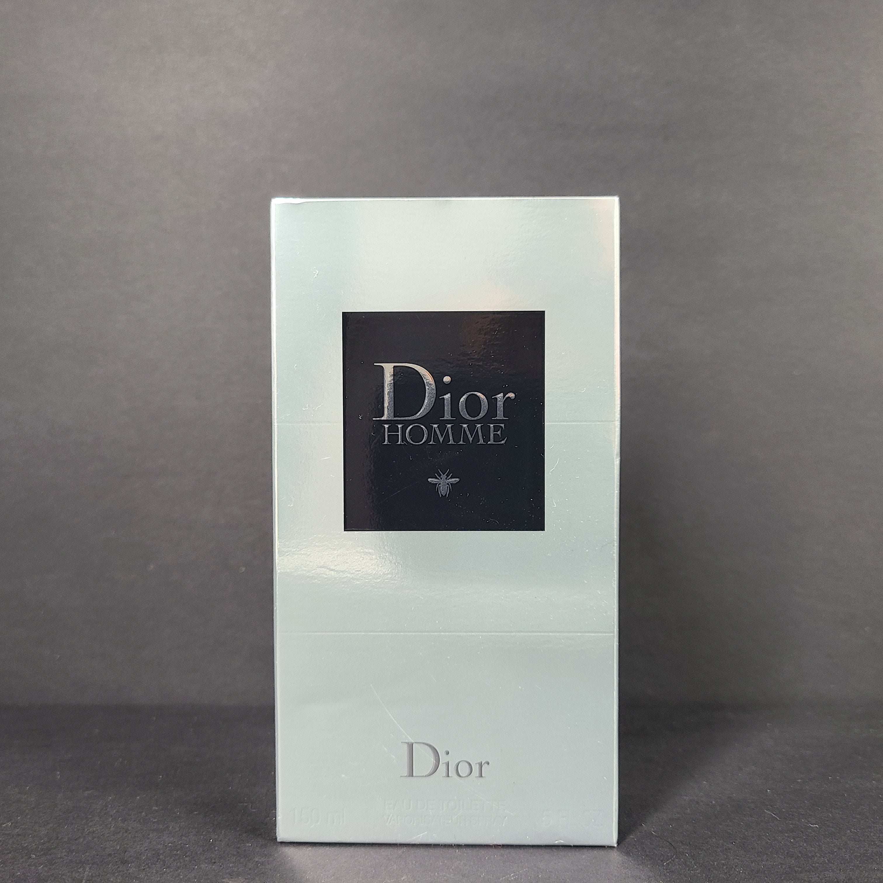 Clear glass perfume bottle labeled Dior Homme Eau de Toilette 150ml with clean, minimalist branding.