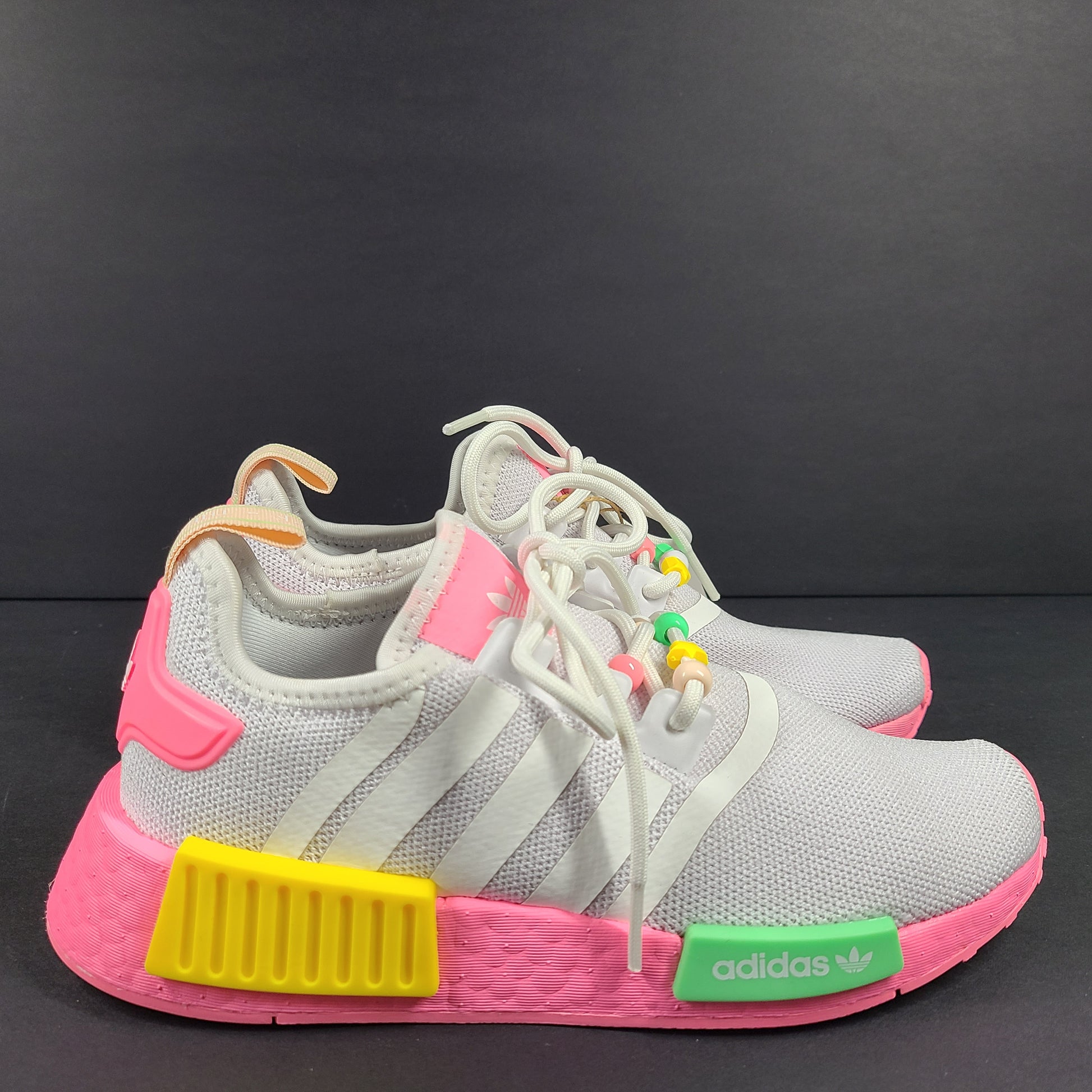 Adidas NMD_R1 J youth sneaker in gray with pink accents and multicolor detailing.