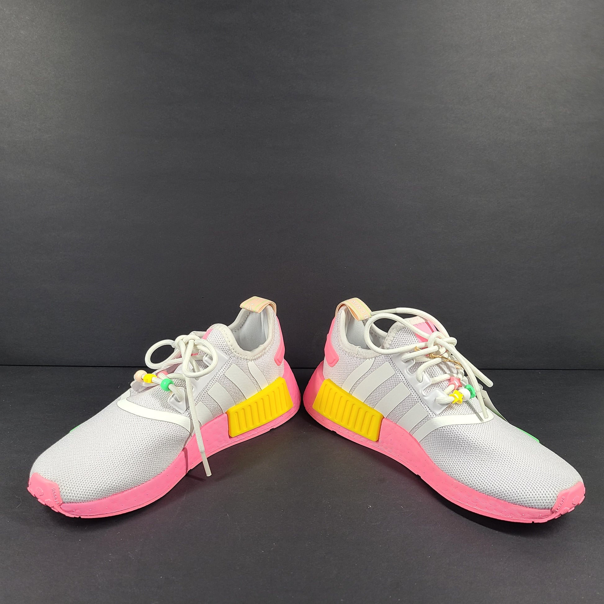 Adidas NMD_R1 J youth sneaker in gray with pink accents and multicolor detailing.
