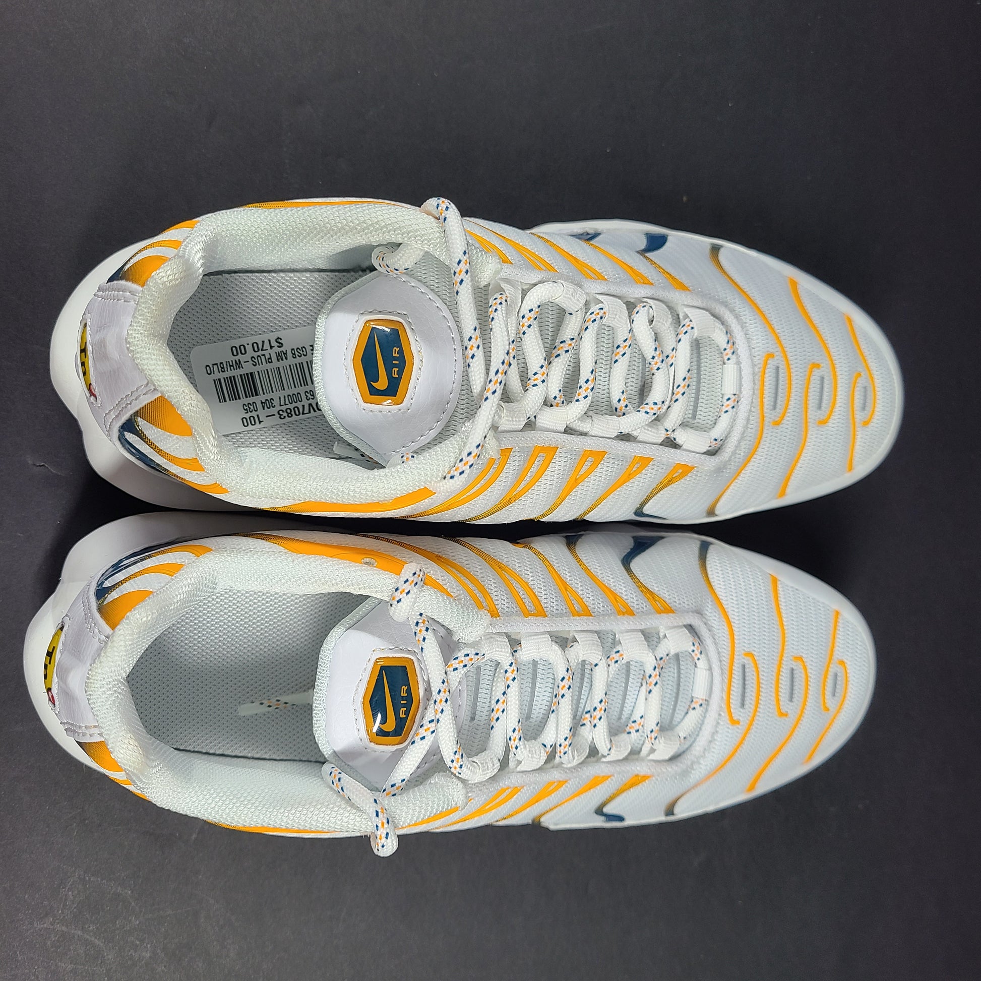 Nike Air Max Plus in white, orange and blue with signature Air cushioning and a youth fit for active wear.