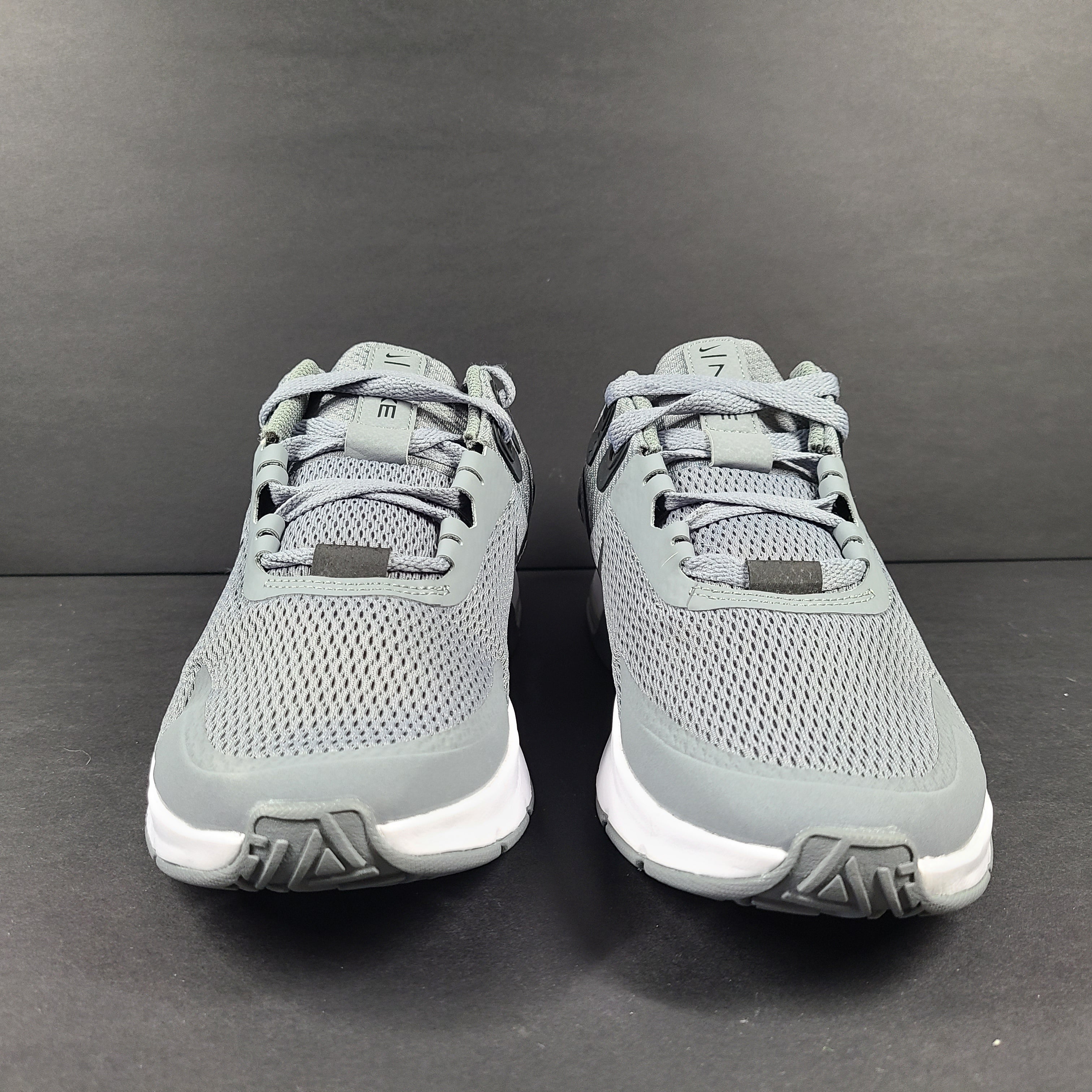 Nike Air Max Alpha Trainer 4 in gray and black featuring Air Max cushioning and a lace-up athletic profile.