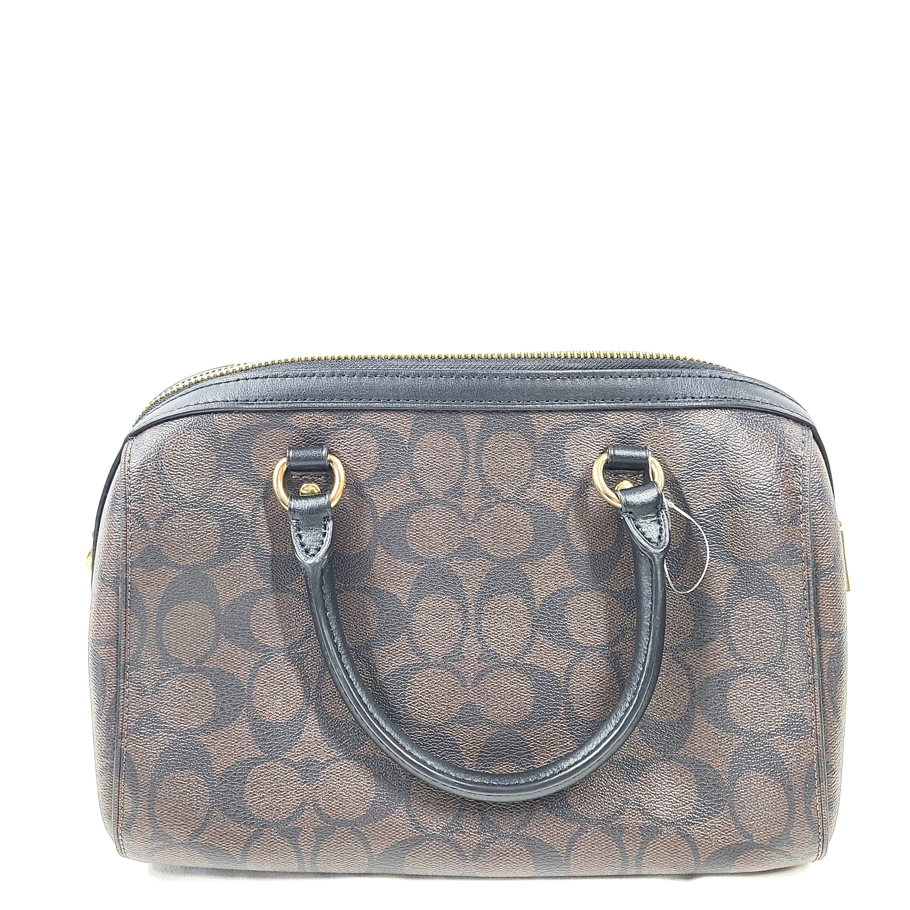 Compact Coach Bennett mini satchel in brown and black with a detachable strap for versatile carry.