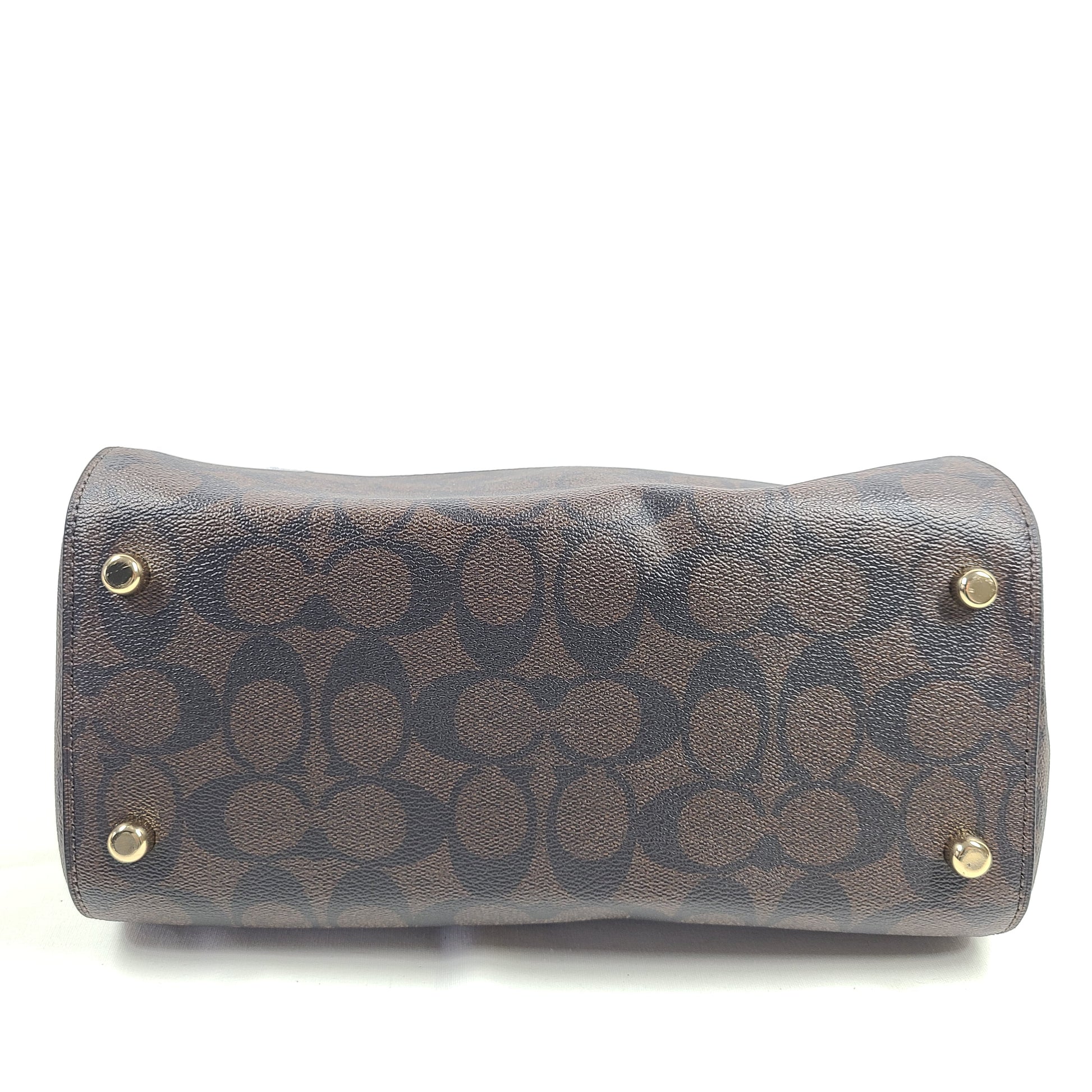 Coach brown signature-print handbag with black accents, including an interior label with the model number.