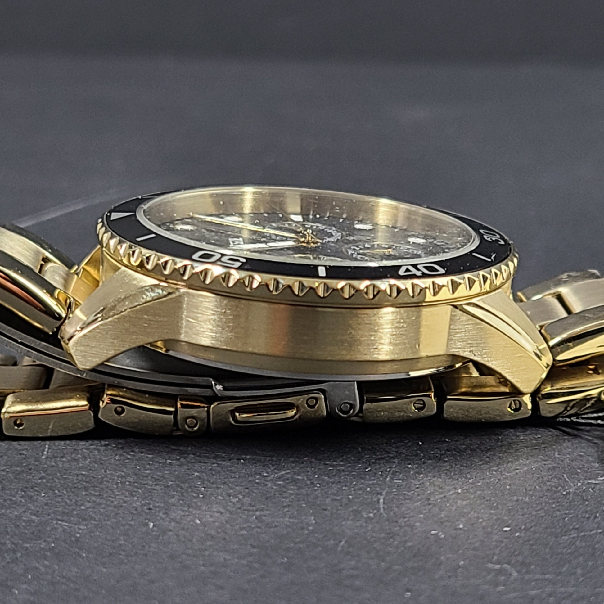 Gold-tone stainless steel his-and-her multifunction watch set with black sunray dials and interchangeable straps.