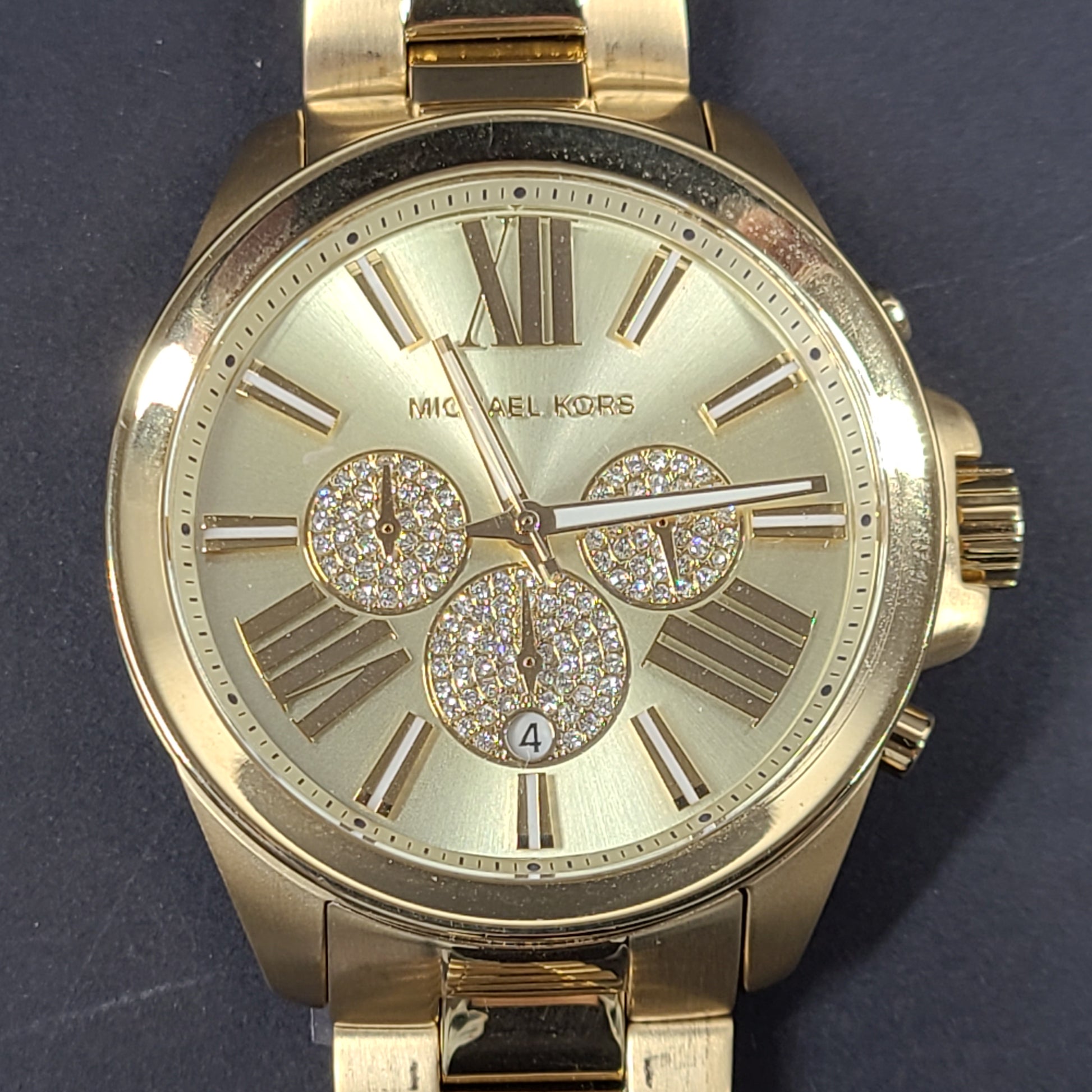Gold-tone Michael Kors Wren chronograph watch with stainless steel bracelet and pavé sub-dials.