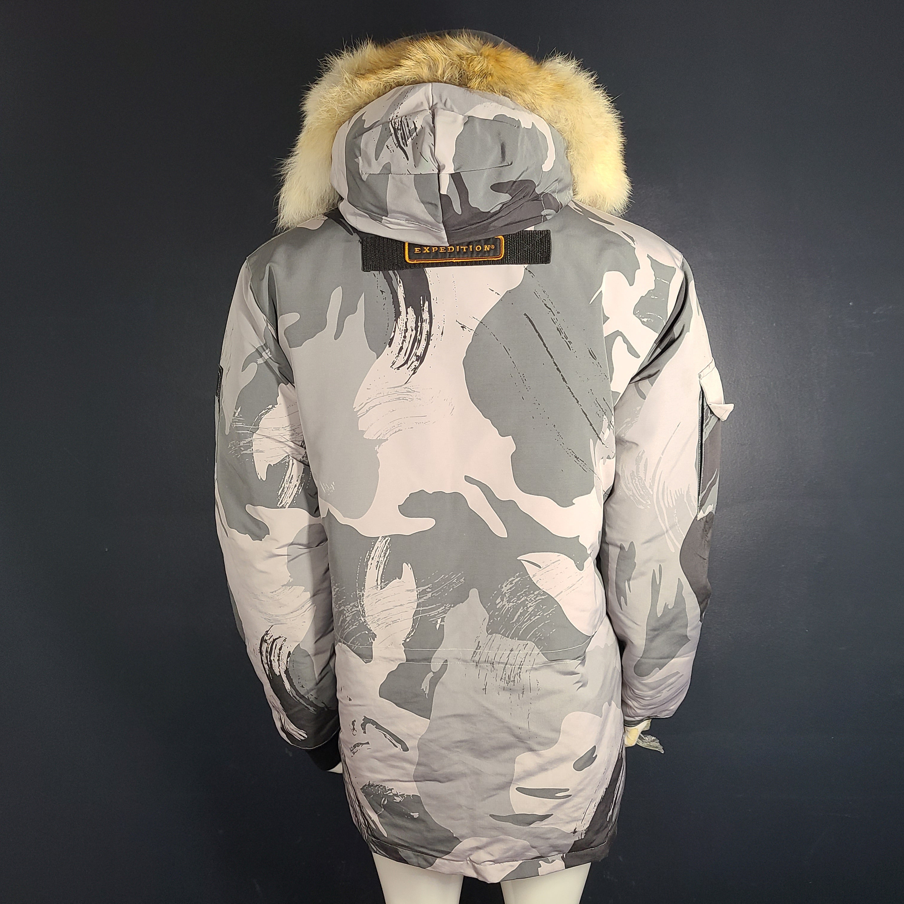Canada Goose Expedition Parka in grey camouflage, size XL, designed for extreme cold with heavy insulation and a fur-trimmed hood.