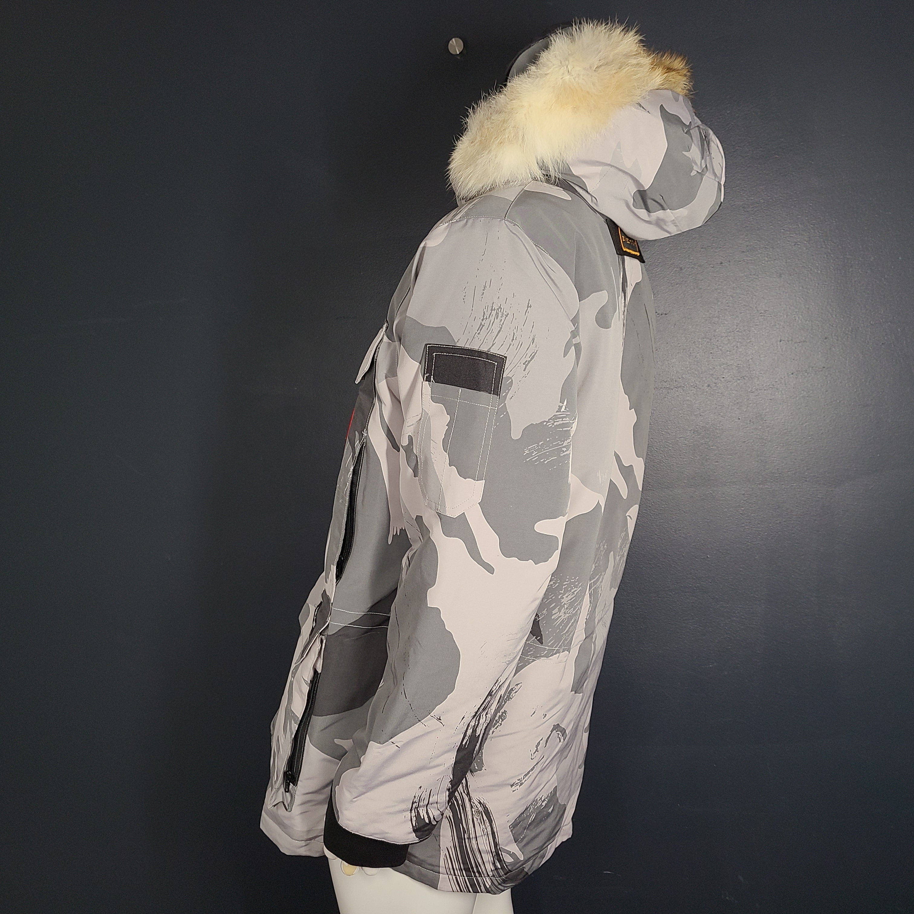 Canada Goose Expedition Parka in grey camouflage, size XL, designed for extreme cold with heavy insulation and a fur-trimmed hood.