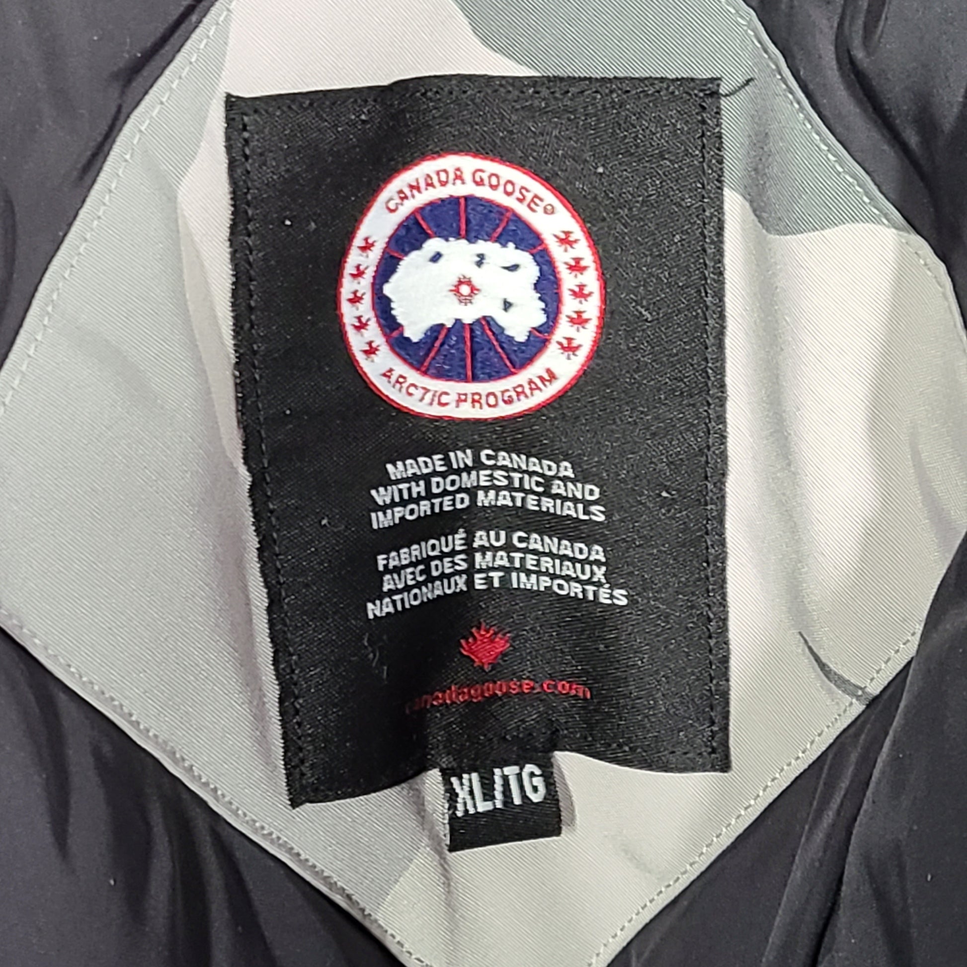Canada Goose Expedition Parka in grey camouflage, size XL, designed for extreme cold with heavy insulation and a fur-trimmed hood.