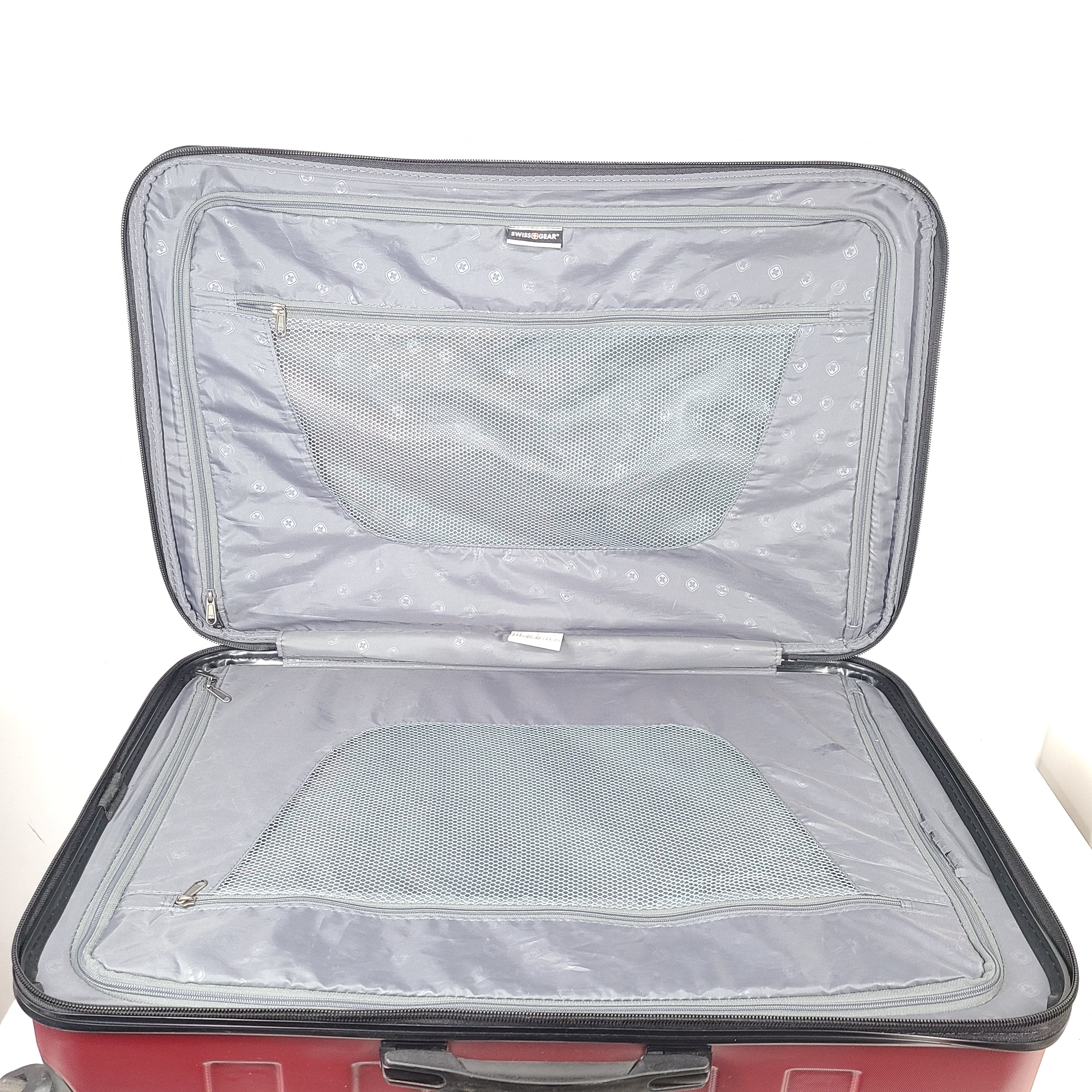 Red SwissGear SW25083 spinner suitcase with four multi-directional wheels and a telescoping handle.